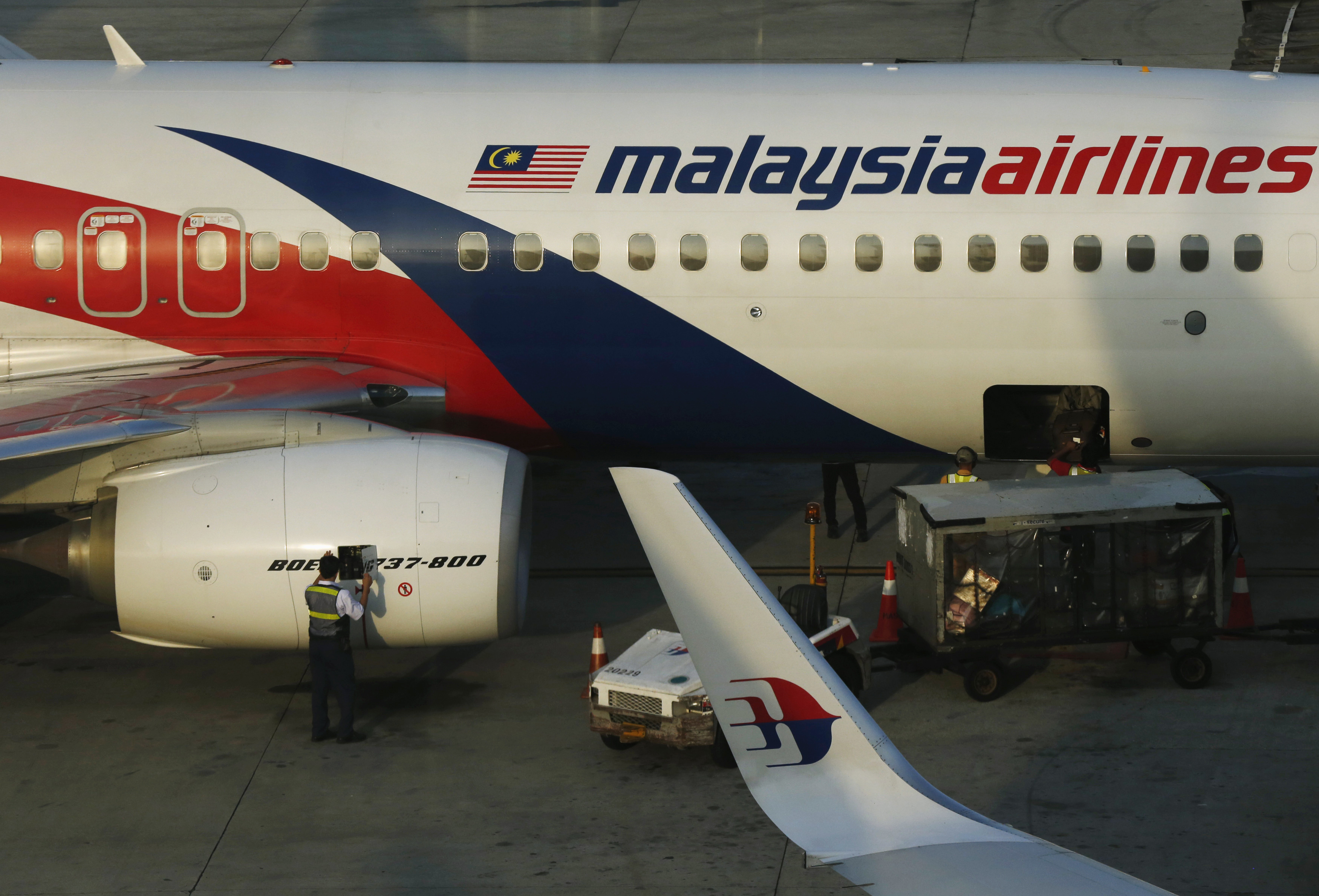 A member of ground crew works on a Malaysia Airlines Boeing 737-800 airplane on the runway at Kuala Lumpur International Airport on July 25, 2014 (Olivia Harris—Reuters)