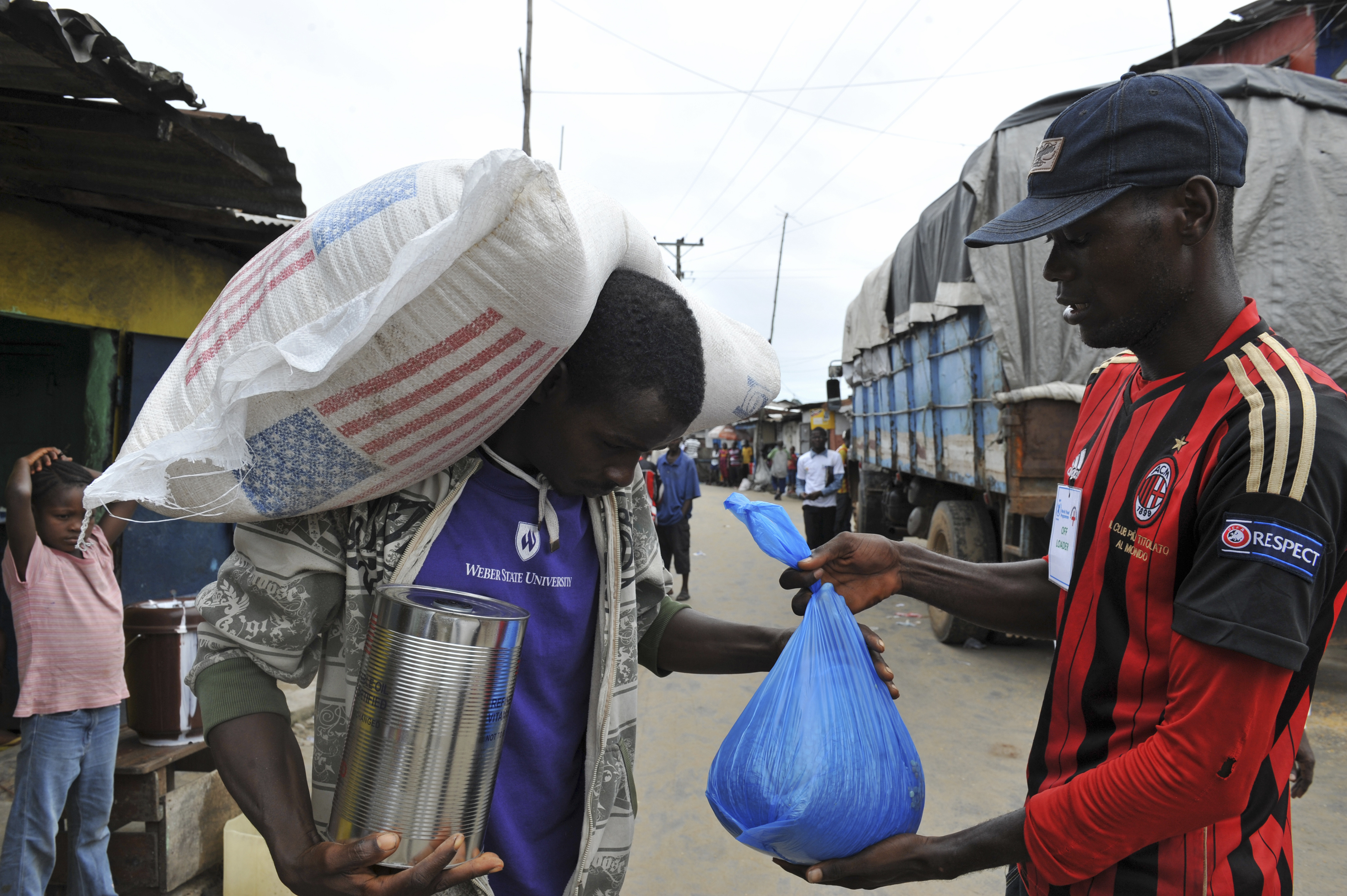 Resident of the West Point neighbourhood, which has been quarantined following an outbreak of Ebola, receives food rations from the United Nations World Food Programme (WFP) in Monrovia
