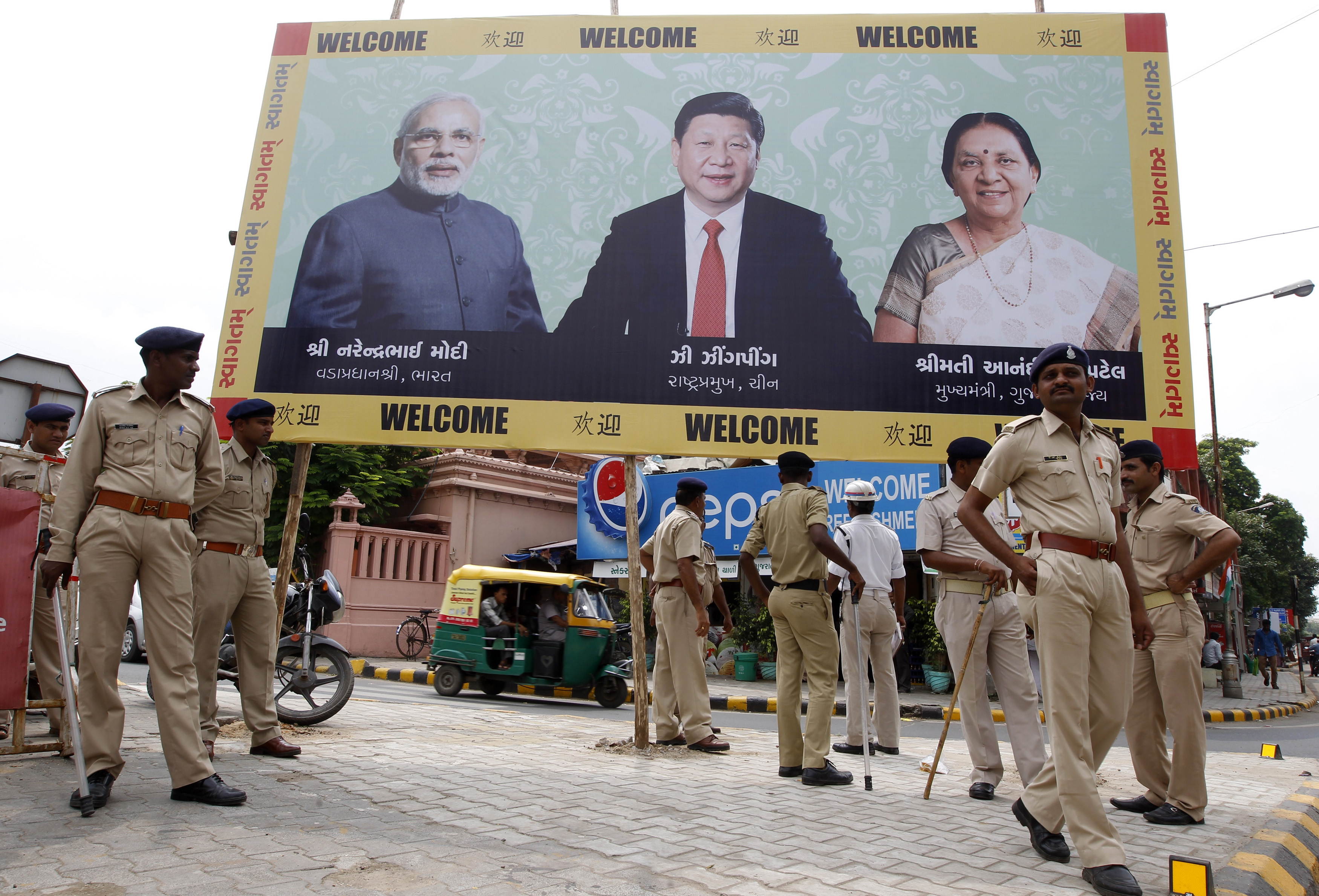 Police personnel stand guard on Sept. 16, 2014, in front of a billboard with images of, from left to right, Indian Prime Minister Narendra Modi, Chinese President Xi Jinping and Gujarat Chief Minister Anandiben Patel ahead of Xi's arrival in Ahmedabad (Amit Dave—Reuters)