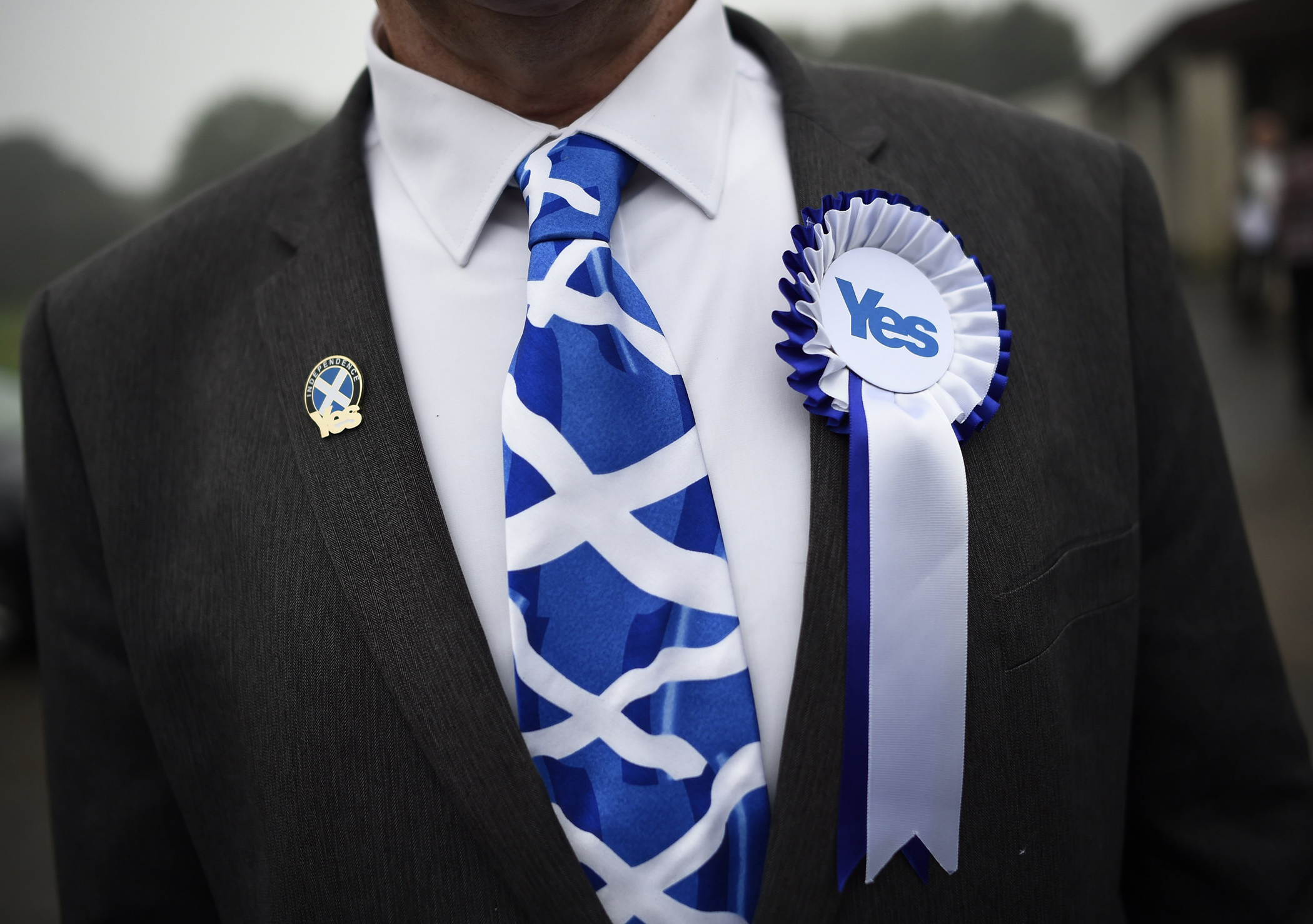 A supporter of the 'Yes' campaign stands outside a polling station as Scotland's First Minister Alex Salmond casts his vote during the referendum on Scottish independence in Strichen, Scotland, Sept. 18, 2014.