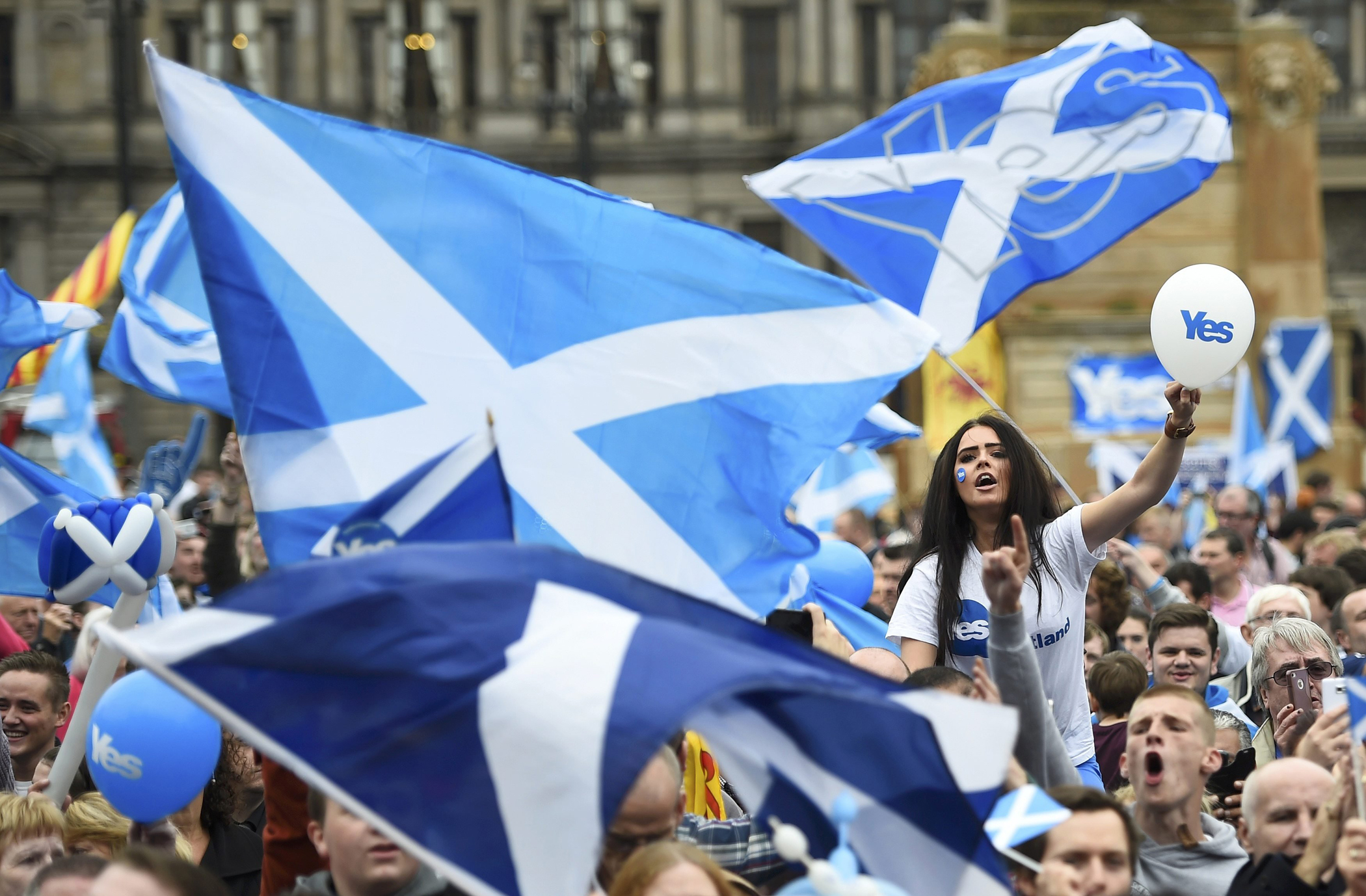 Campaigners wave Scottish Saltires at a 'Yes' campaign rally in Glasgow, Scotland, Sept. 17, 2014.