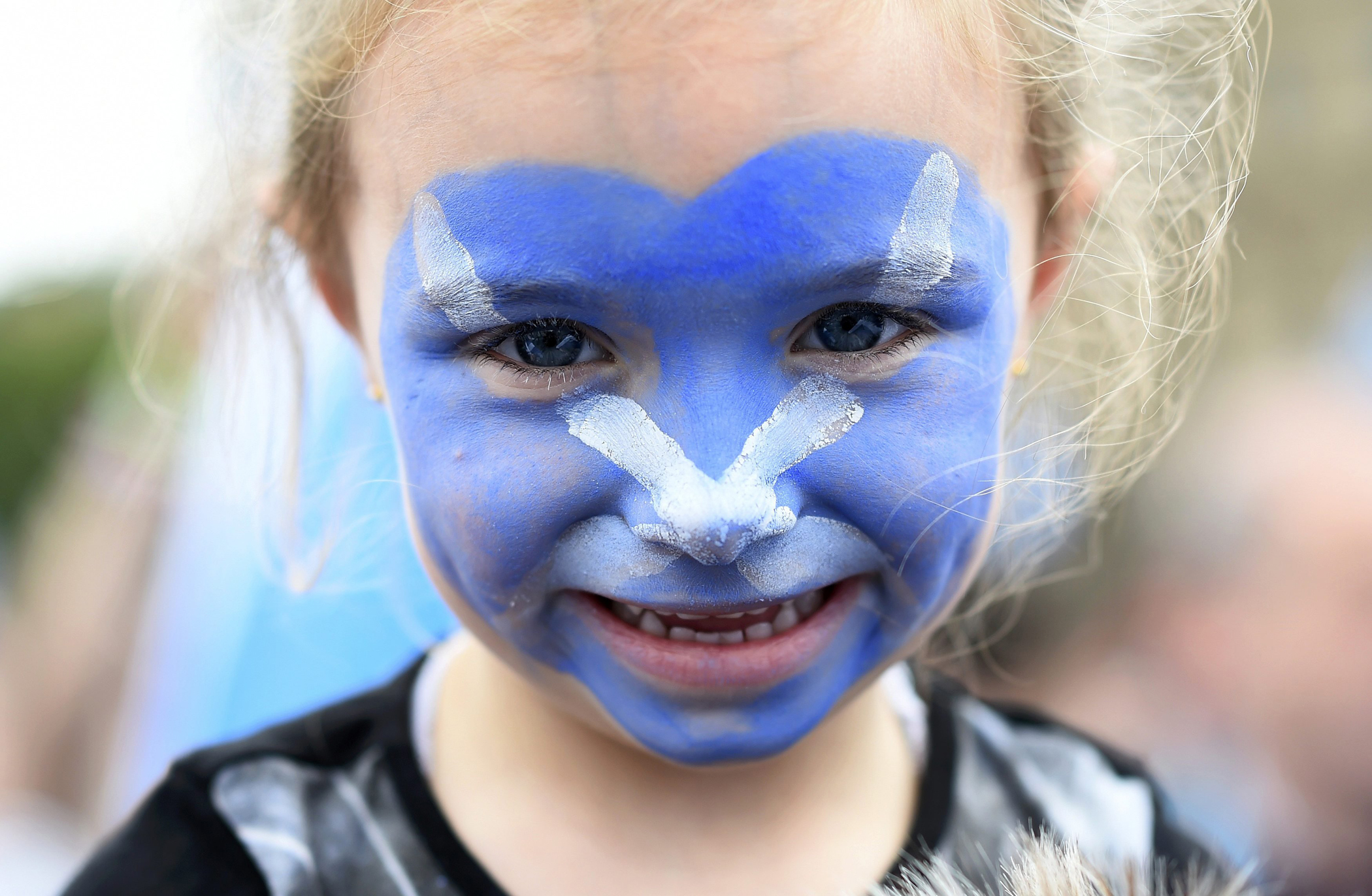 A young girl with a Scottish Saltire painted on her face waits outside a 'Yes' campaign rally in Glasgow, Scotland, Sept. 17, 2014.