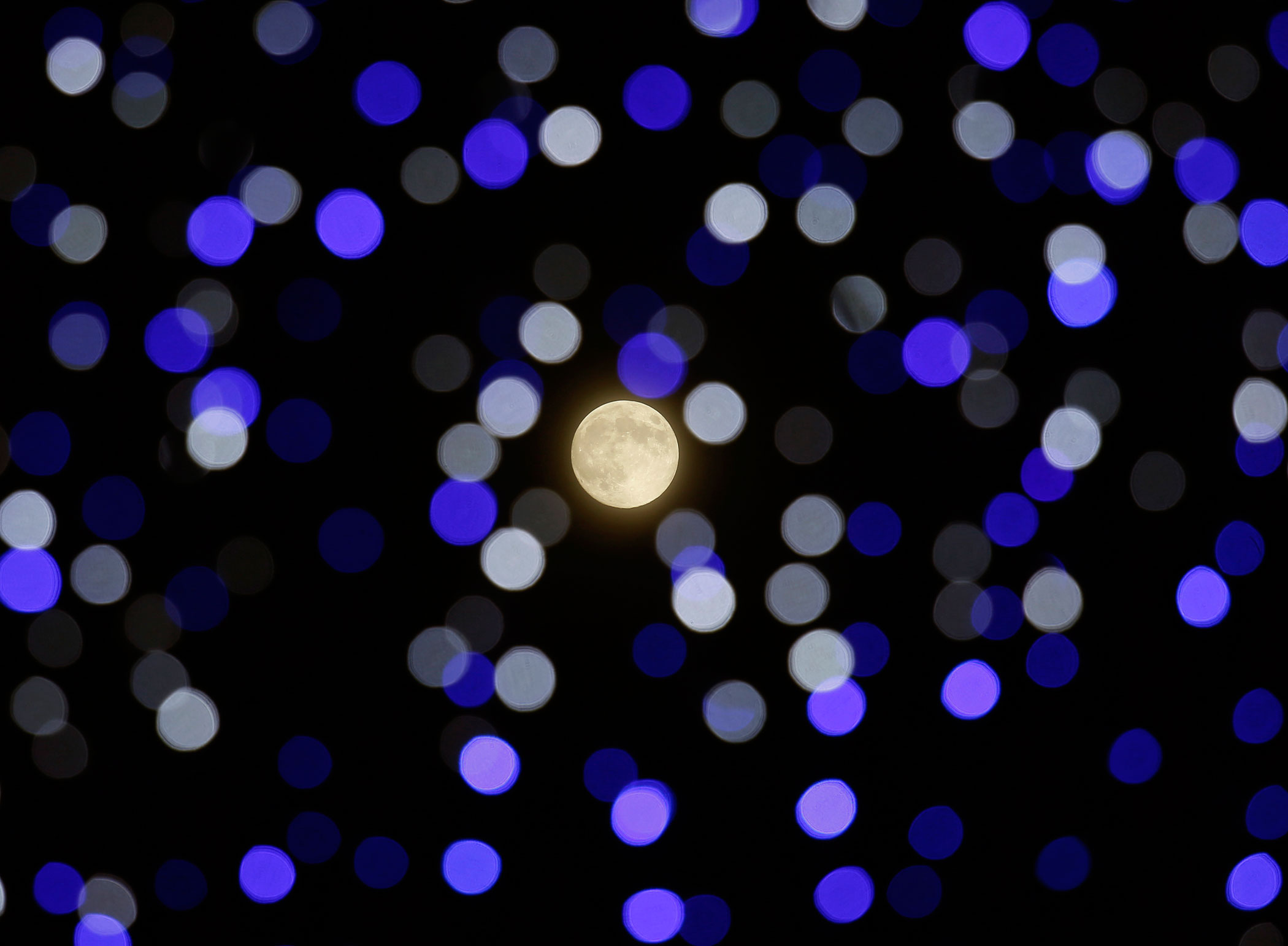 The harvest supermoon shines in between lighting installation during Mid-Autumn or Lantern Festival at Hong Kong's Victoria Park on Sept. 8, 2014.