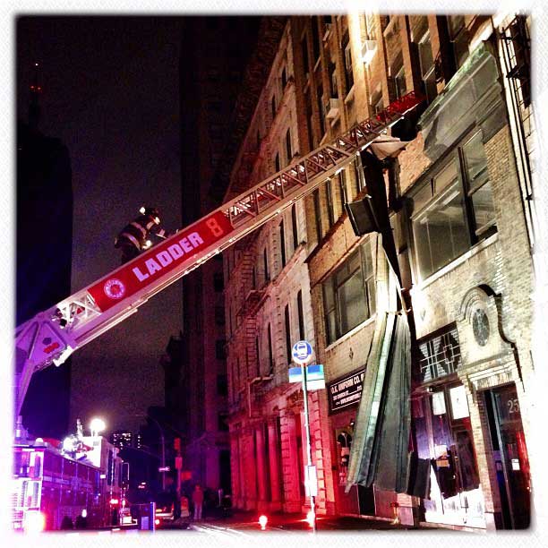 The following photographs were taken Oct. 30, 2012A firefighter from Engine 1 ascends a tower ladder to cut a dangling piece of facade from a building on Broadway, near Franklin Street, in Manhattan