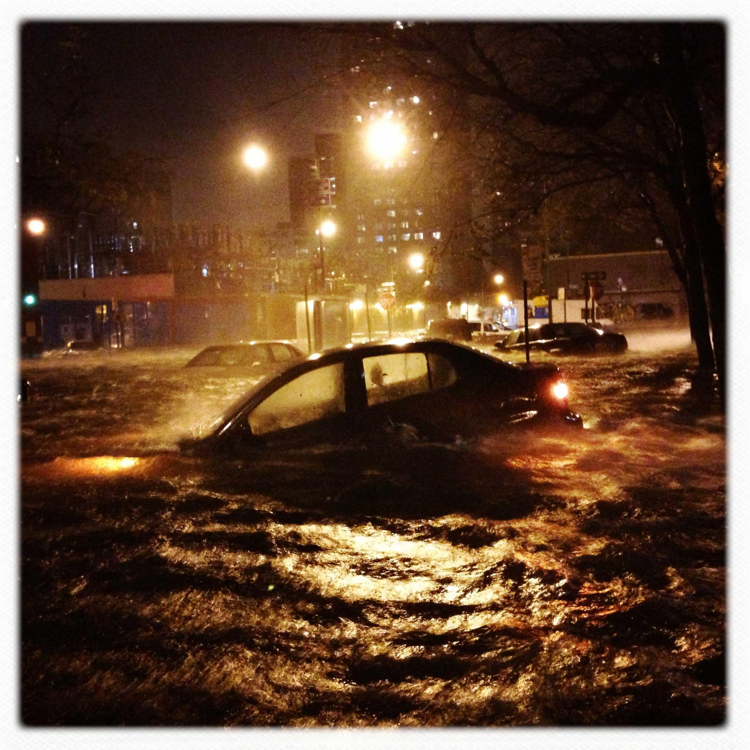 A car is submerged in floodwater on Avenue C, near 14th Street, in Manhattan
