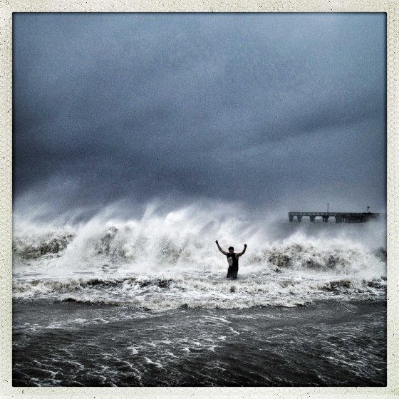 A man stands in the heavy surf near Coney Island as Sandy moves towards land
