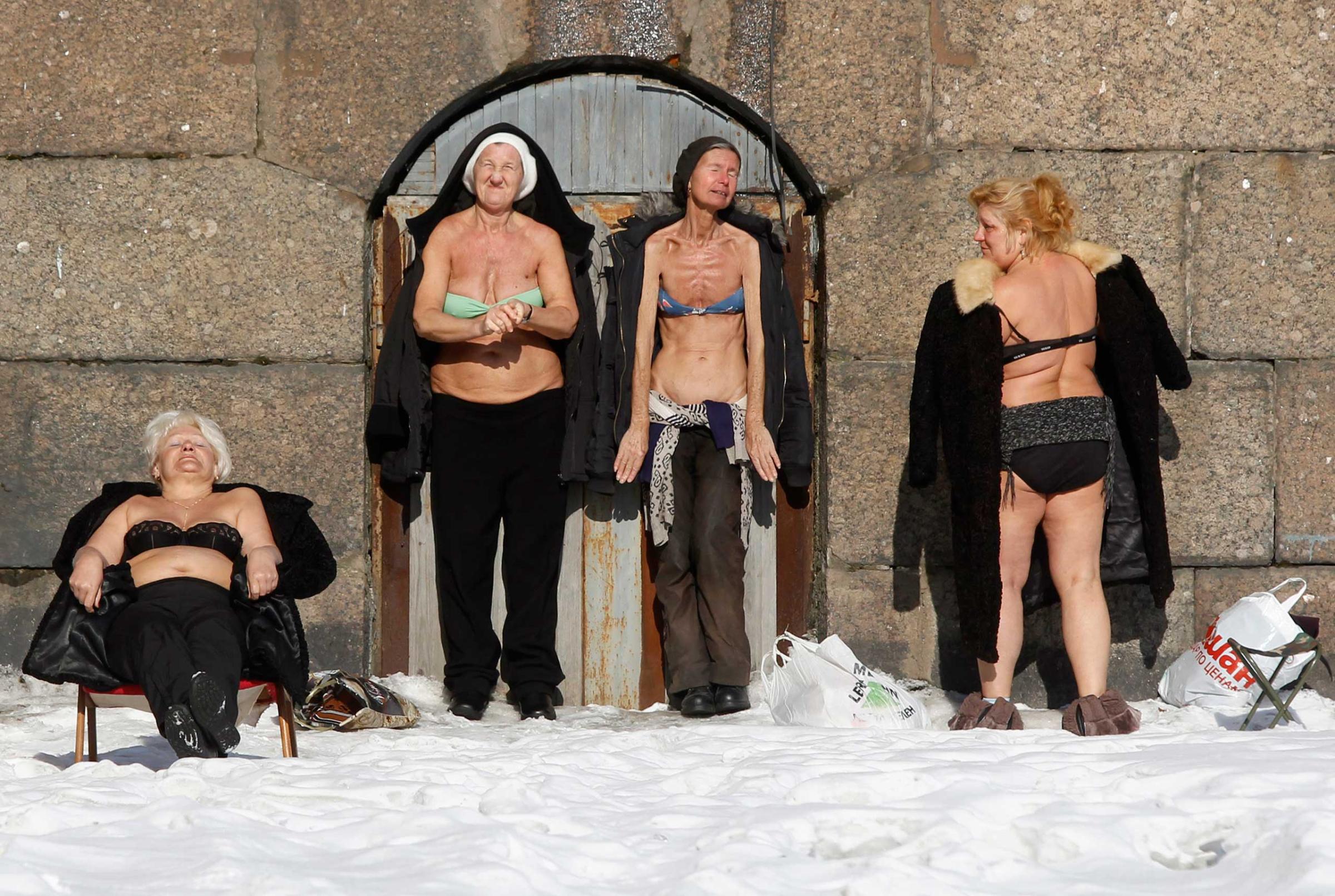 People sunbathe by the wall of the Peter and Paul Fortress in St. Petersburg