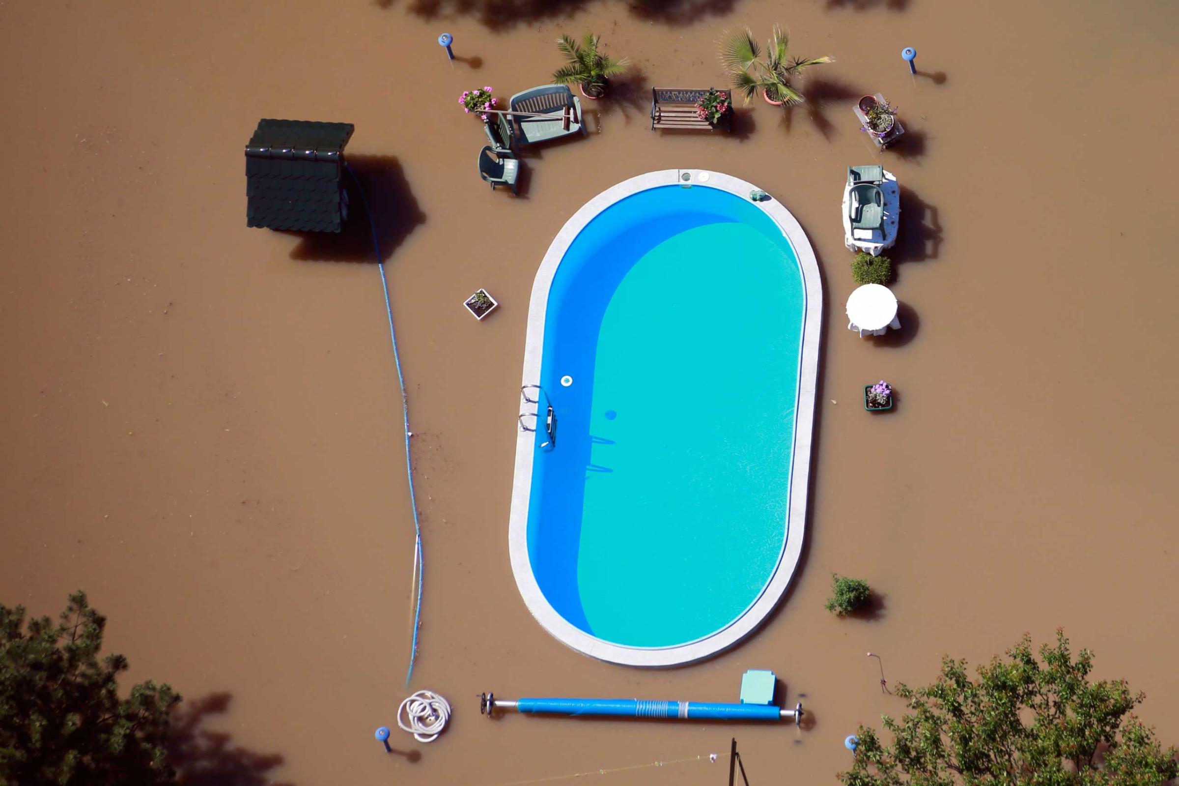 Garden with swimming pool is inundated by waters of Elbe river during floods near Magdeburg