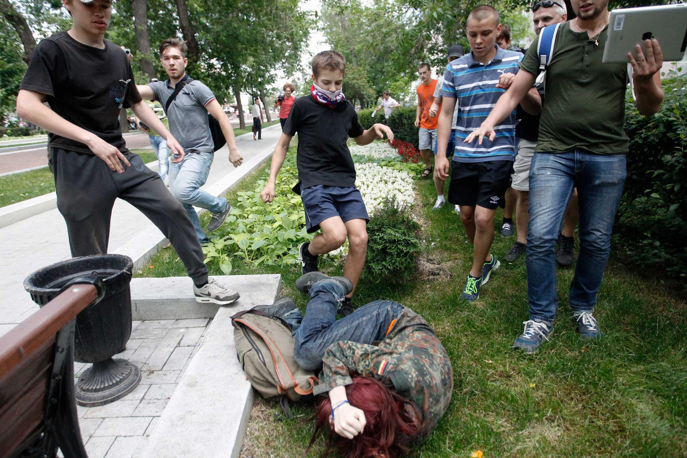 Youths kick a gay rights activist during a protest against a proposed new law termed by the State Duma as "against advocating the rejection of traditional family values" in central Moscow