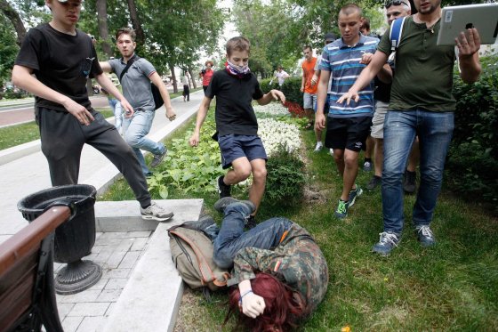 Youths kick a gay rights activist during a protest against a proposed new law termed by the State Duma as 