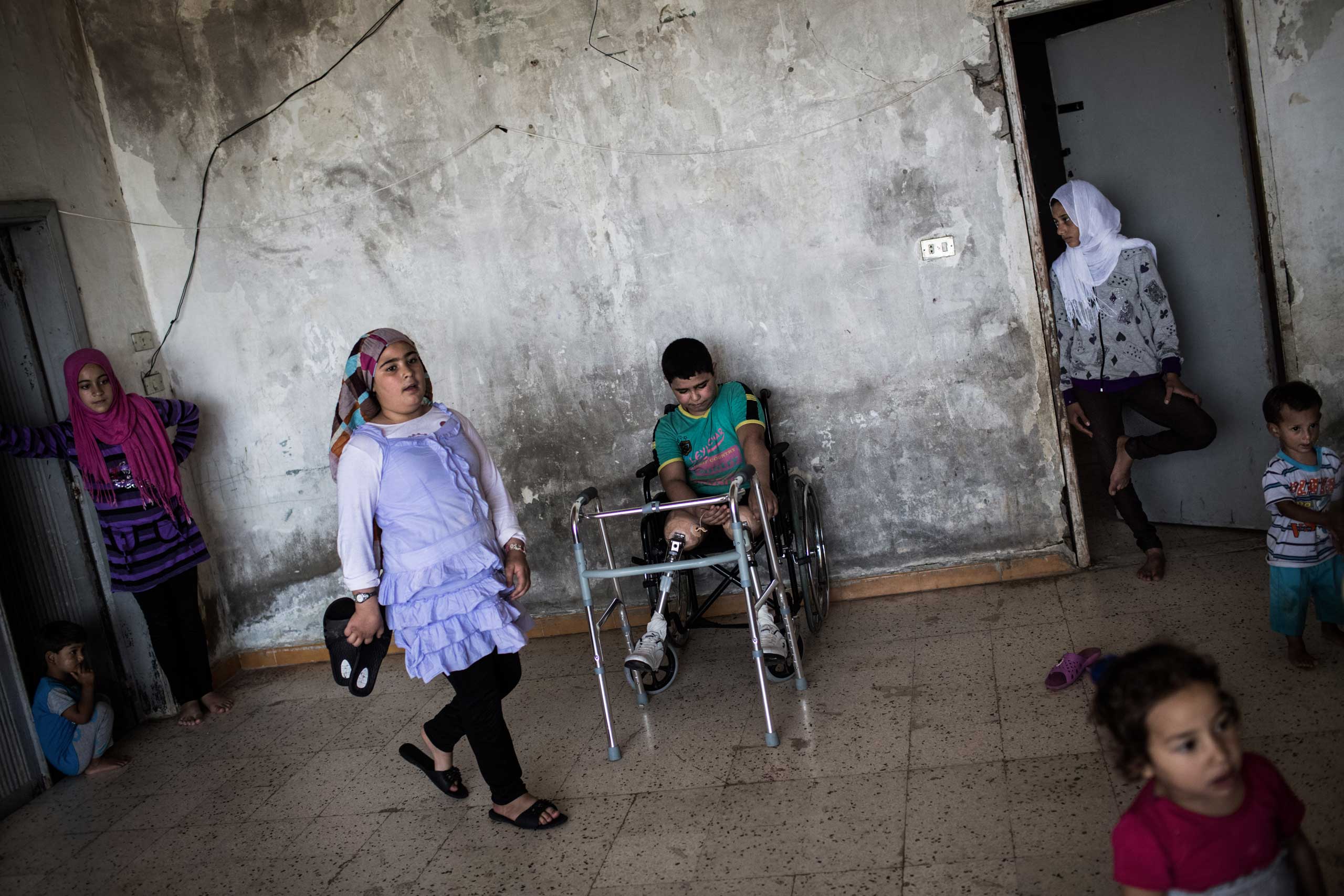Hussein, 10, sits at a shelter in Tripoli, Lebanon, June 18, 2014. He was presumed dead after a bomb hit his home in Syria but found unconscious at the morgue. Hussein is learning to walk again after receiving two prosthetic legs.
