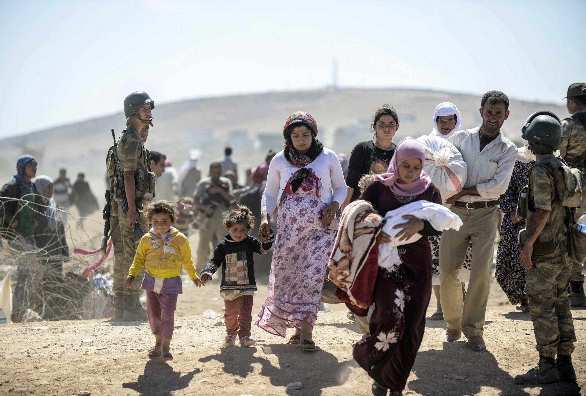 Syrian Kurds cross the border from Syria into Turkey near the southeastern town of Suruc in Sanliurfa province, on Sept. 20, 2014.