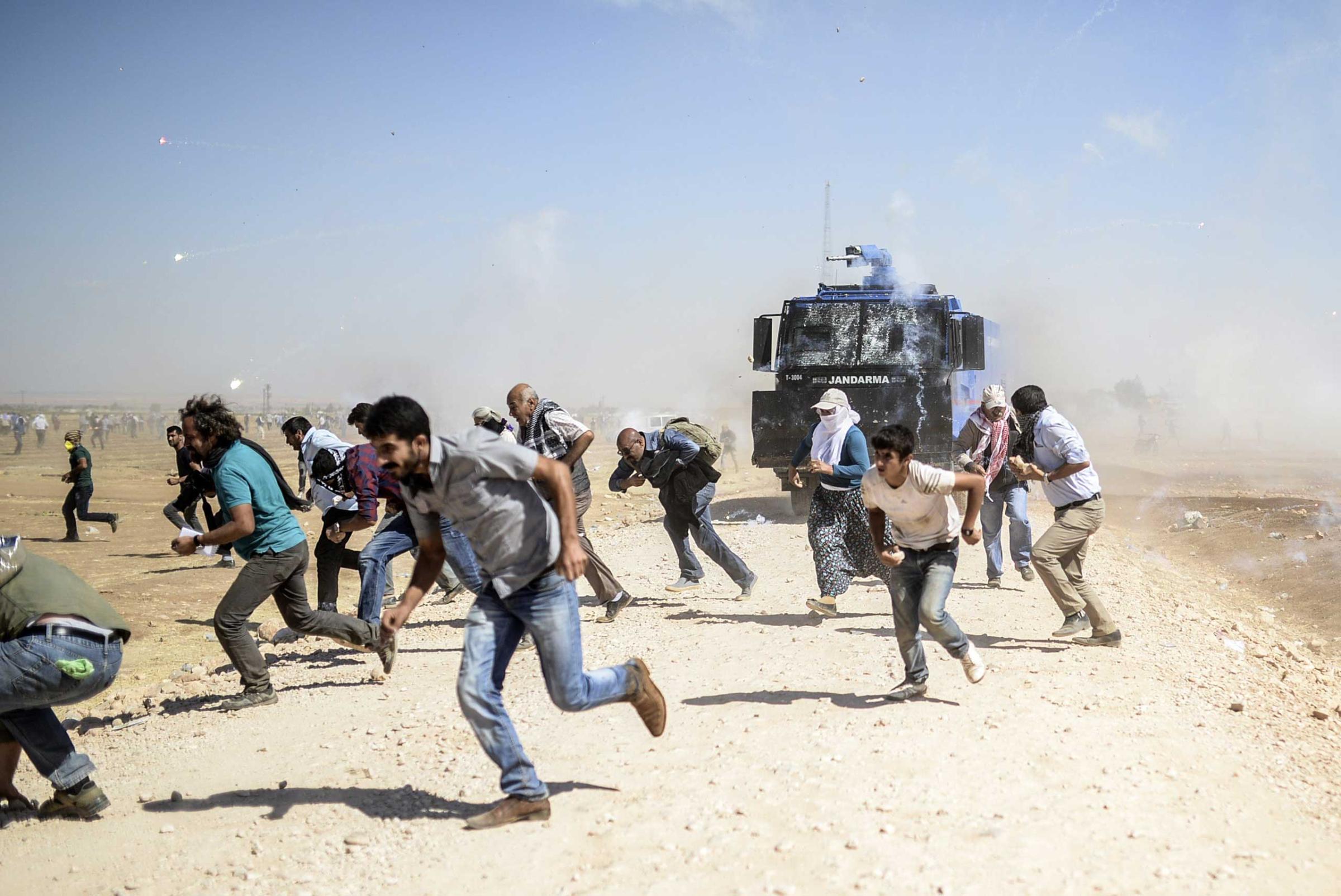 Kurdish protestors clash with Turkish soldiers near the Syrian border after Turkish authorities temporarily closed the border at the southeastern town of Suruc in Sanliurfa province, on Sept. 22, 2014.