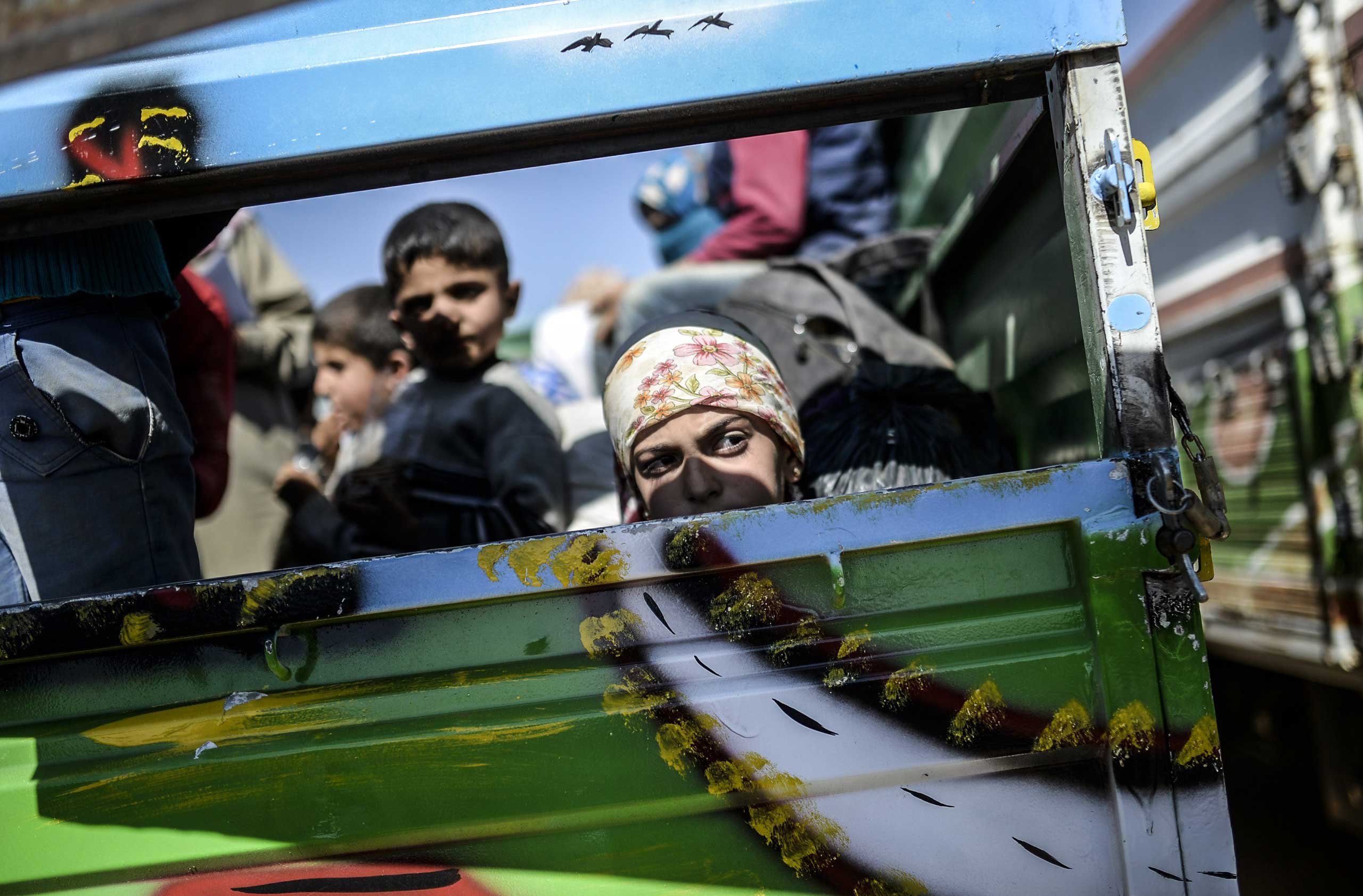 Syrian Kurds sit in a truck after crossing the Syrian-Turkish border at the southeastern town of Suruc in Sanliurfa province on Sept. 23, 2014.