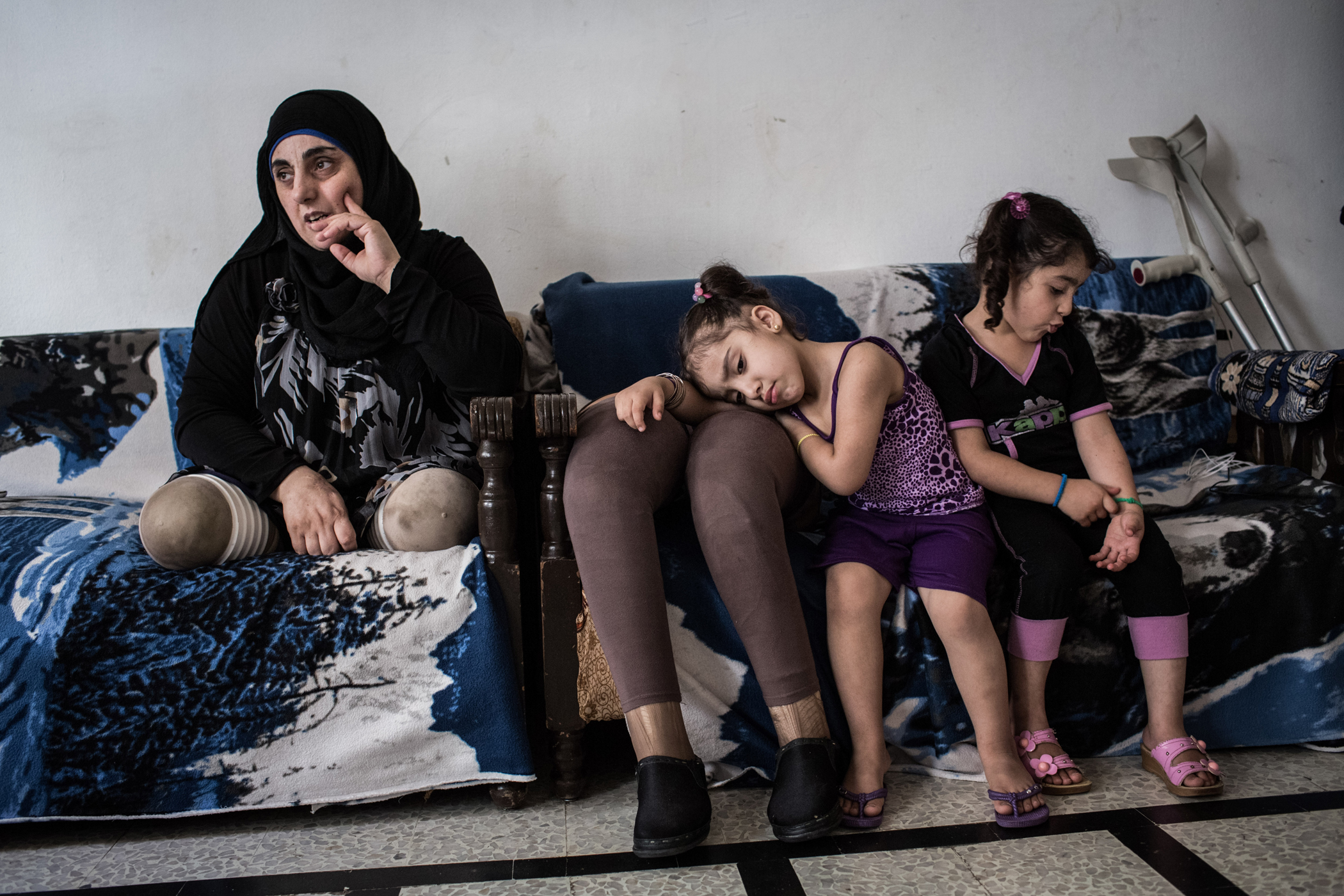 Hasna, pictured with her nieces, Aseel and Hadeel, 4, in their shared home in Tripoli, on June 11, 2014.  In March 2012, Hasna, her husband and her two children were traveling on a motorcycle in Qusayr when a bomb fell nearby: “My daughter was sleeping in my arms, she never woke up,” recalls Hasna of the day she lost her legs, husband and two children all at once. Her husband was still alive as they were being transported to a field hospital: “My husband was holding my hand the entire time, up until we were driven to the town of Lousseh. It was there they informed me that my husband had breathed his last breath.” That same night Hasna reached a hospital in Lebanon at around 4:00 am and lost consciousness . She had seen her legs and suspected they were lost.  After four surgeries, both legs were lost and  Handicap International, an NGO working in the region, supplied her with prosthetics: “It was hard and difficult but now I always try to focus on the positive things. I don't want to be sad and angry, I don't want the negative feelings to take control of me.” UNHCR / A. McConnell / June 2014