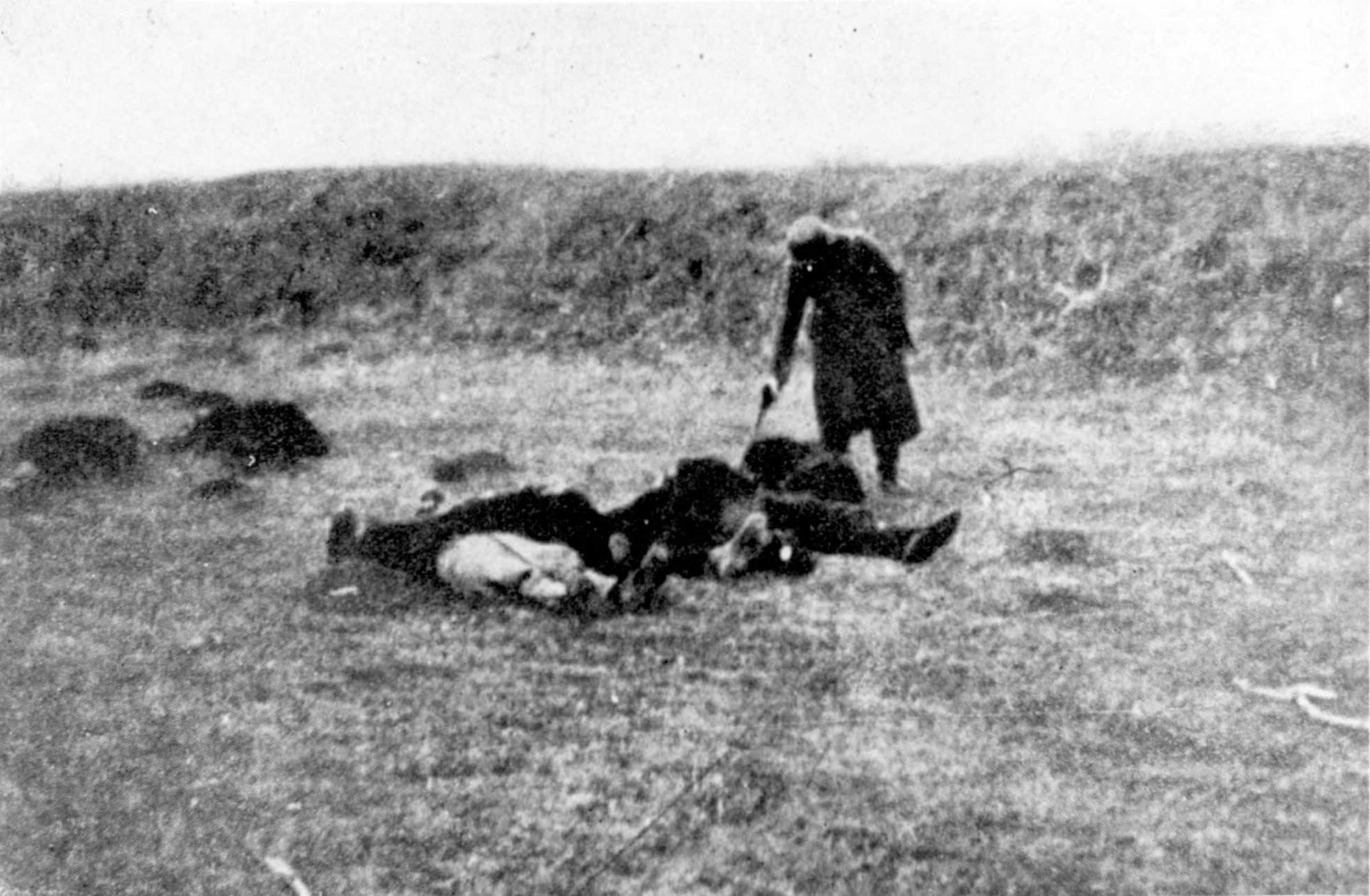 A German soldier shooting those who remained alive after a massacre in Yugoslavia, c. 1941.