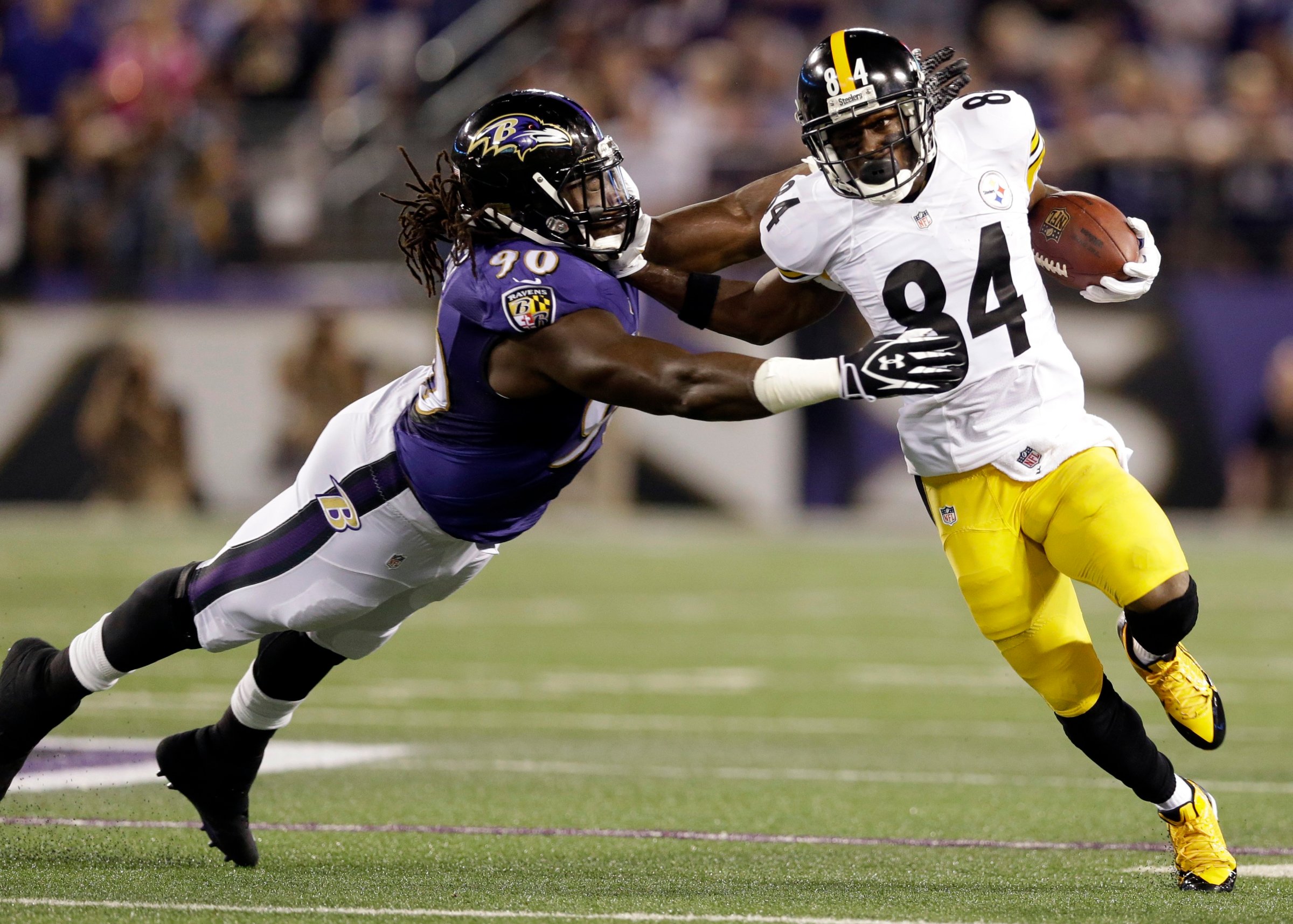 Baltimore Ravens linebacker Pernell McPhee is pushed away by Pittsburgh Steelers wide receiver Antonio Brown during the first half of an NFL football game on Sept. 11, 2014, in Baltimore.