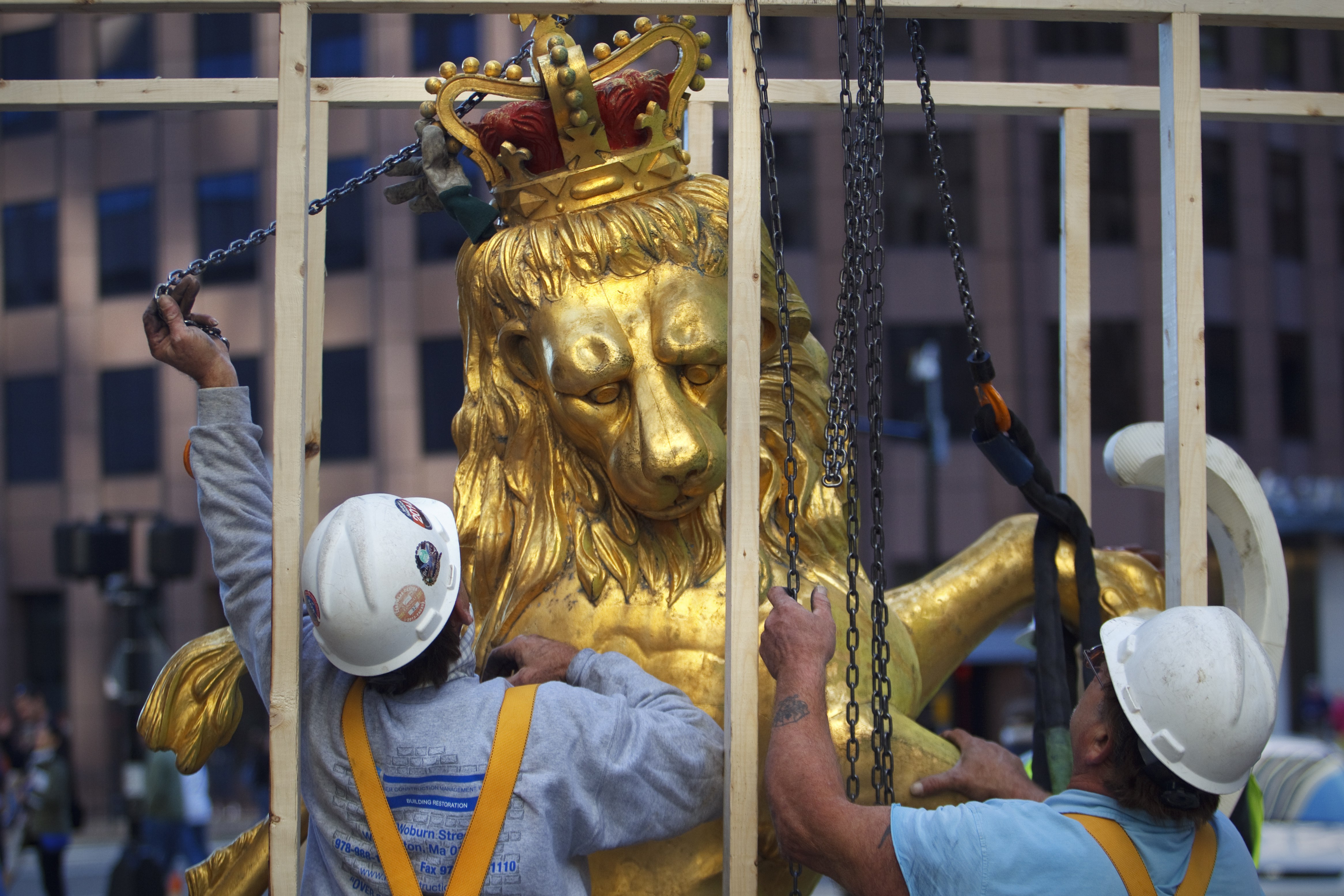 In this Sept. 14, 2014, photo, a lion statue is removed from atop the Old State House on Washington Street in Boston (Dina Rudick—AP)