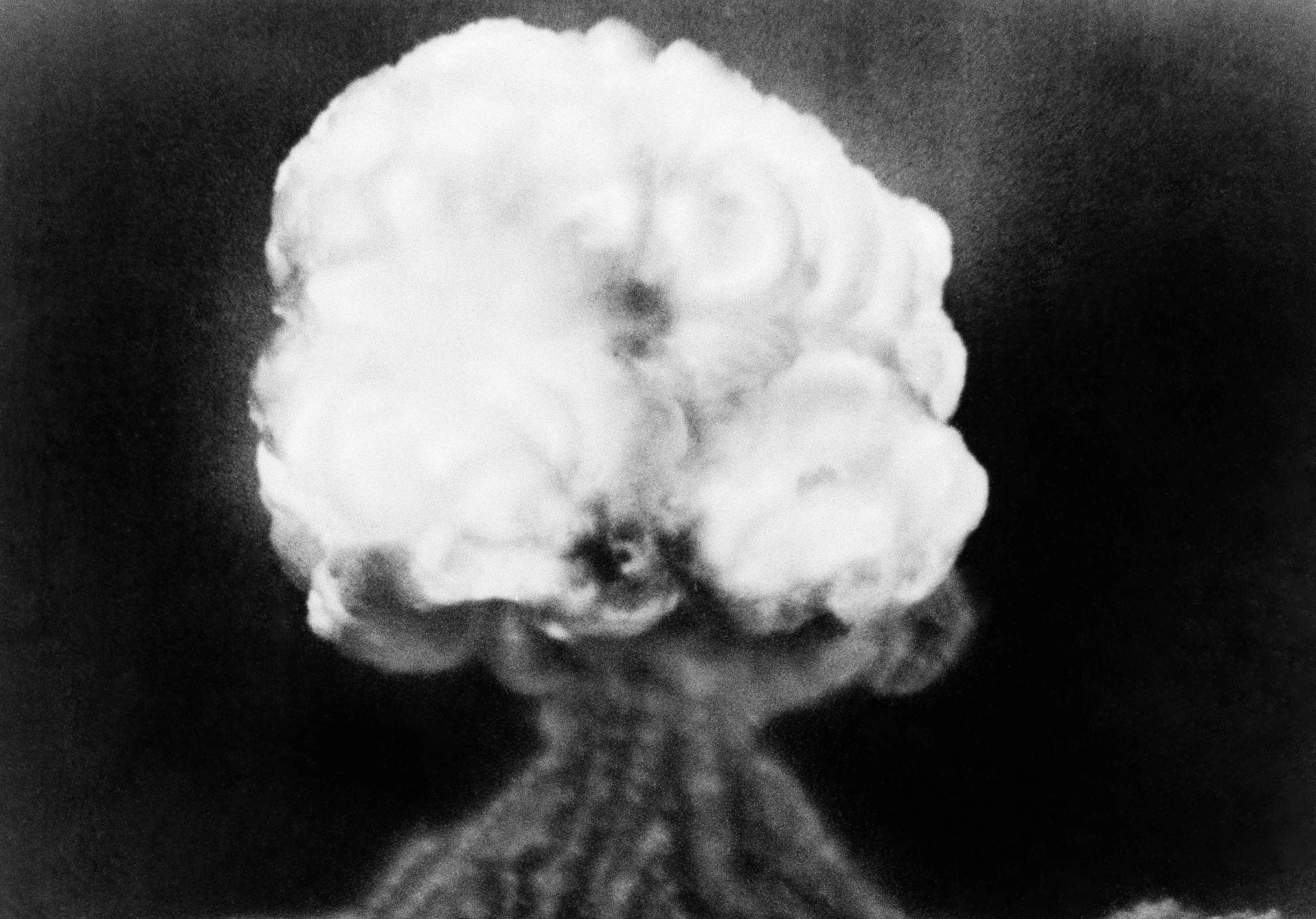 This is the mushroom cloud of the first atomic explosion at Trinity Test Site, New Mexico on July 16, 1945. It left a half-mile wide crater, ten feet deep at the vent and the sand within the crater had been burned and boiled into a highly radioactive, jade-green, glassy crust.