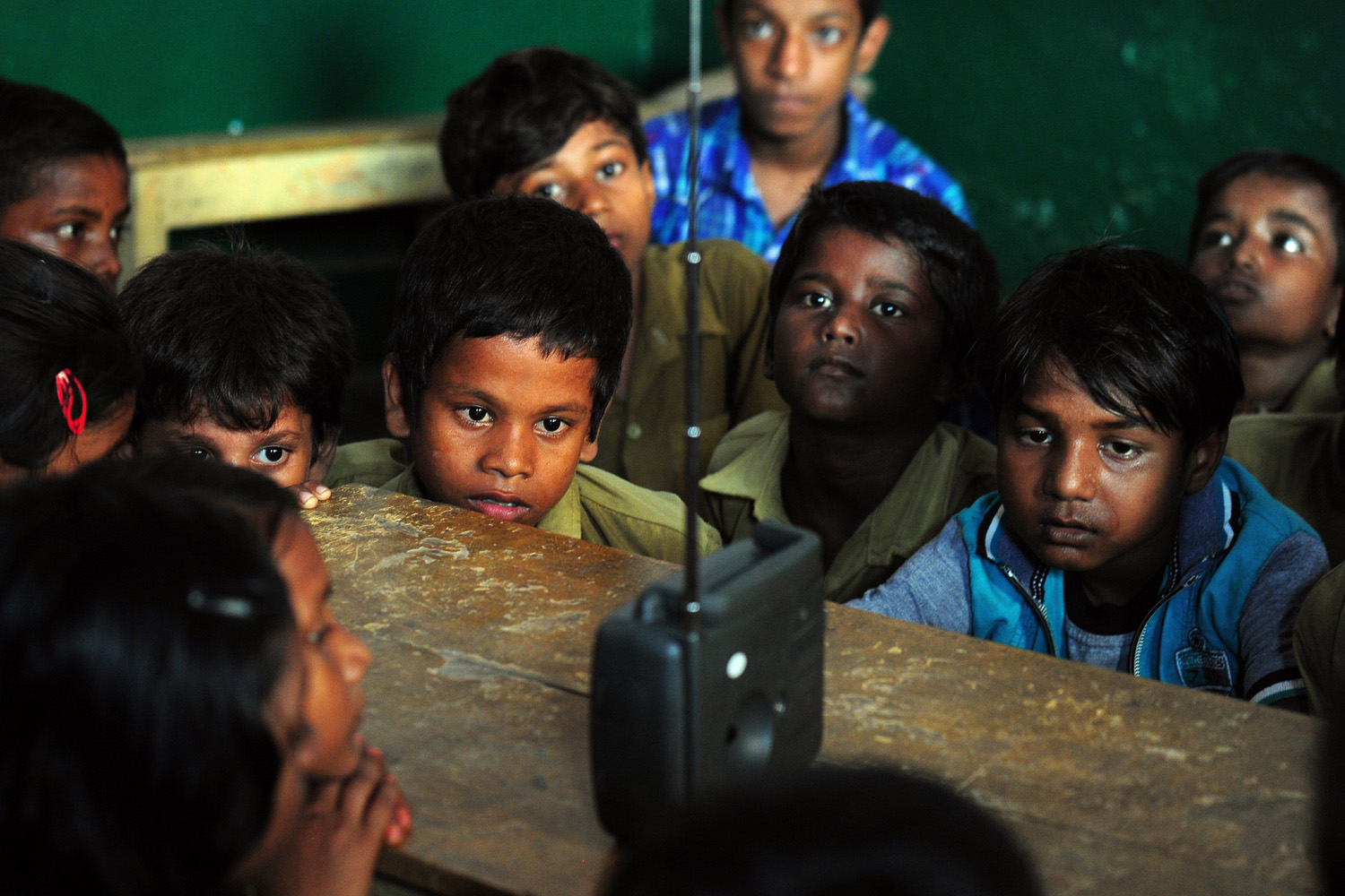 Sept. 5, 2014. Indian schoolchildren crowd around a radio as they listen to a broadcast by Indian Prime Minister Narendra Modi delivering his Teachers' Day speech at a primary municipal school at Bakshi Kala Daraganj in Allahabad.
