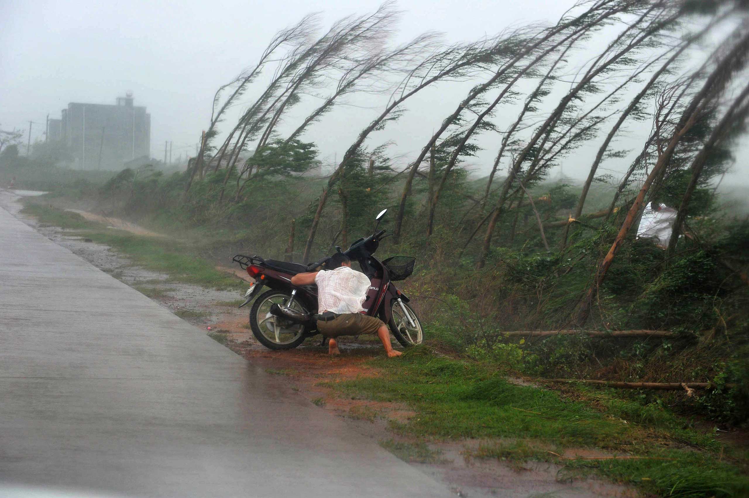 Sept. 16, 2014. A man takes shelter amid strong rainfall in Zhanjiang, China,