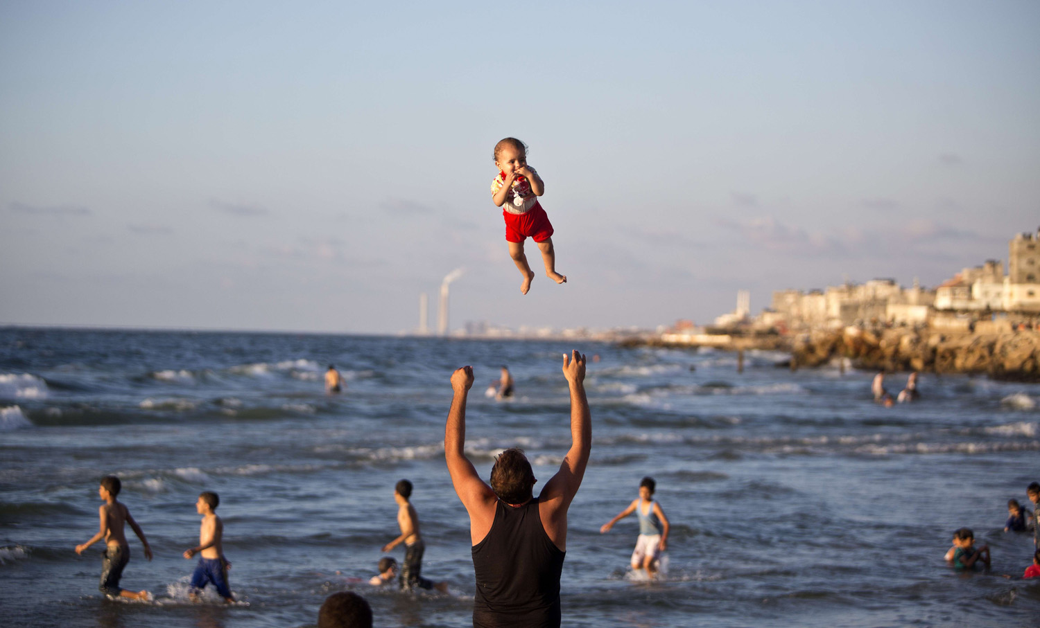 A Palestinian man plays with his baby on a beach on Sept.7, 2014 in Gaza city.