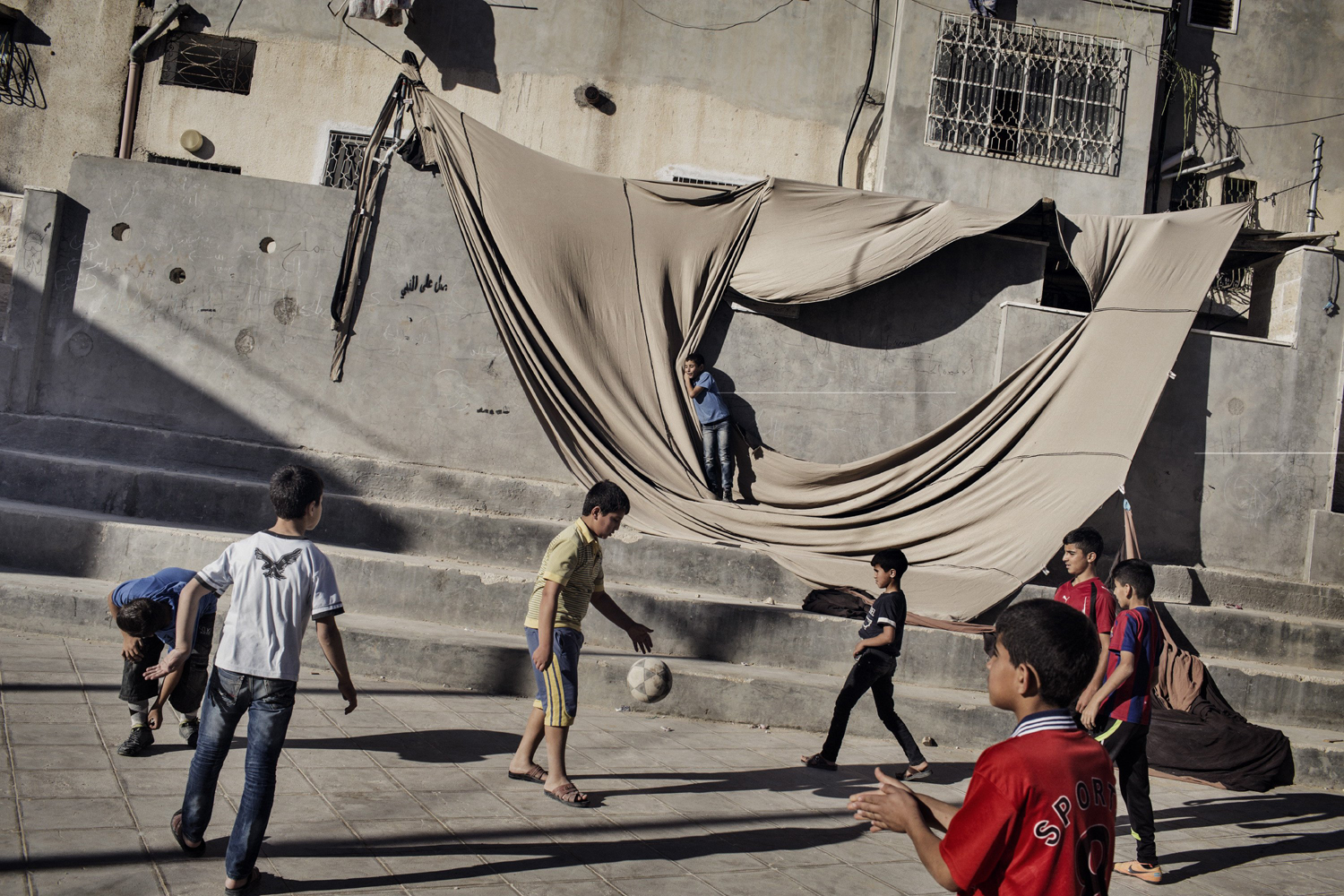 Children play soccer in a plaza in Al Fawwar, a Palestinian refugee camp in the West Bank, June 15, 2014.