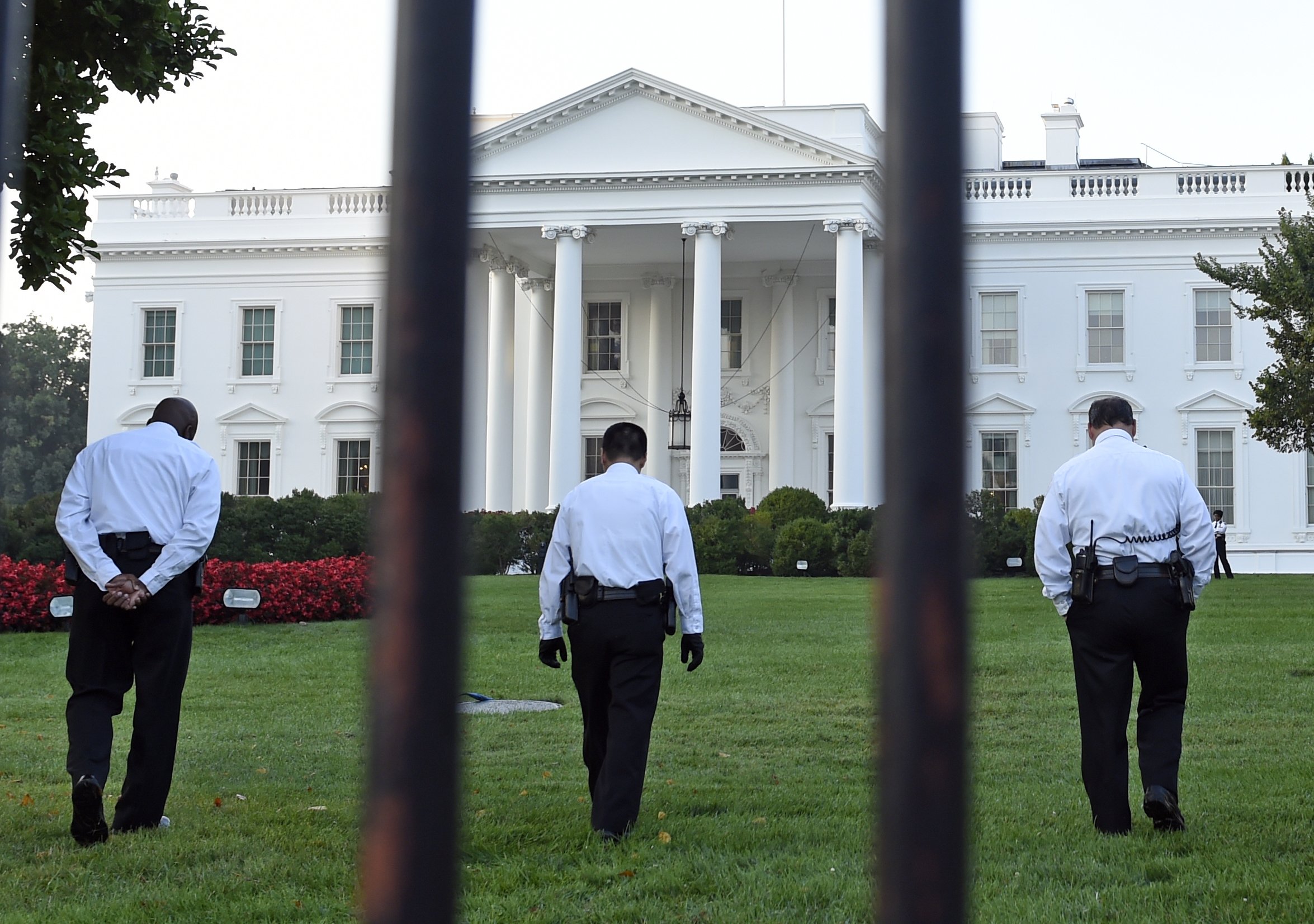 Uniformed Secret Service officers walk along the lawn on the North side of the White House in Washington on Sept. 20, 2014. The Secret Service is coming under renewed scrutiny after a man scaled the White House fence and made it all the way through the front door before he was apprehended. (Susan Walsh—AP)