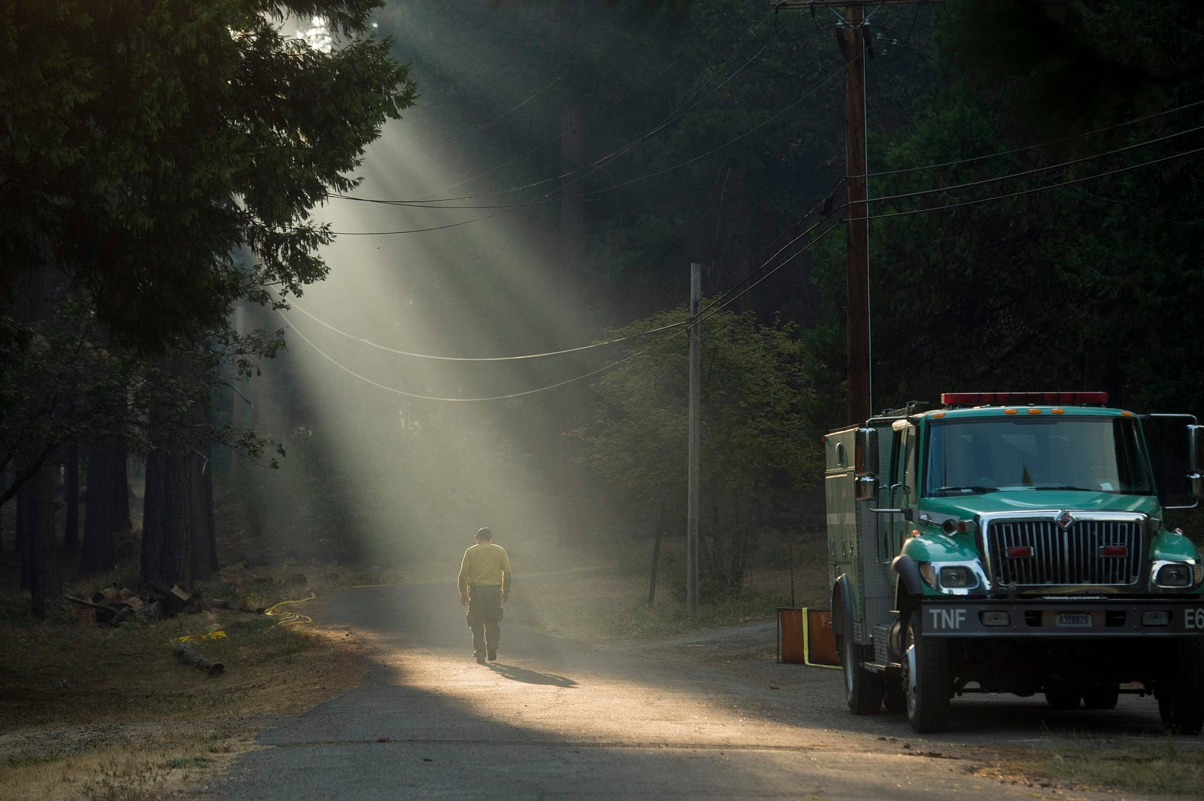 A firefighter walks through smoke while battling the King Fire near Fresh Pond, California