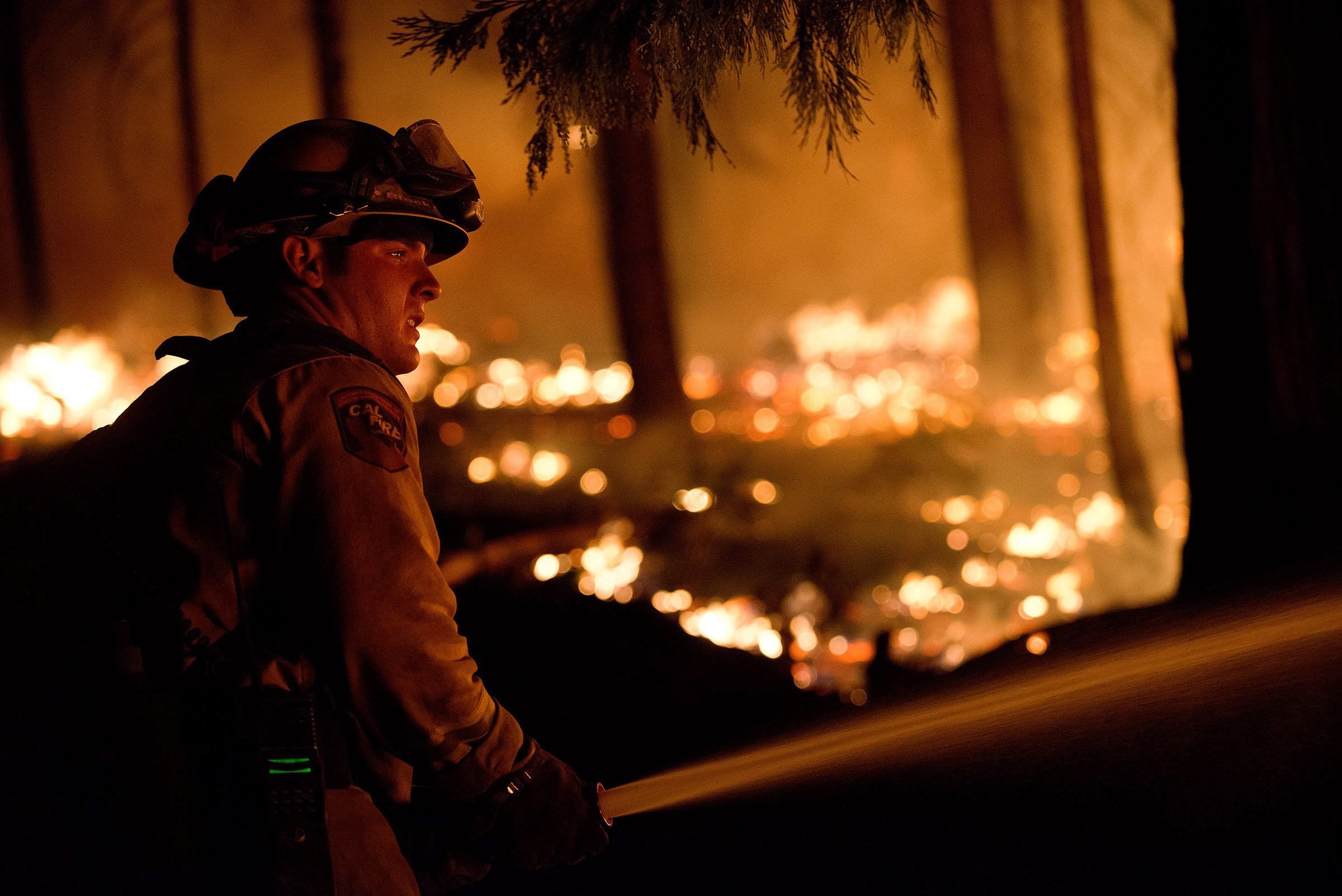 A firefighter works the line of a controlled burn to create a safe zone around homes close to the King Fire in the town of Pollock Pines, Calif. on Sept. 17, 2014.