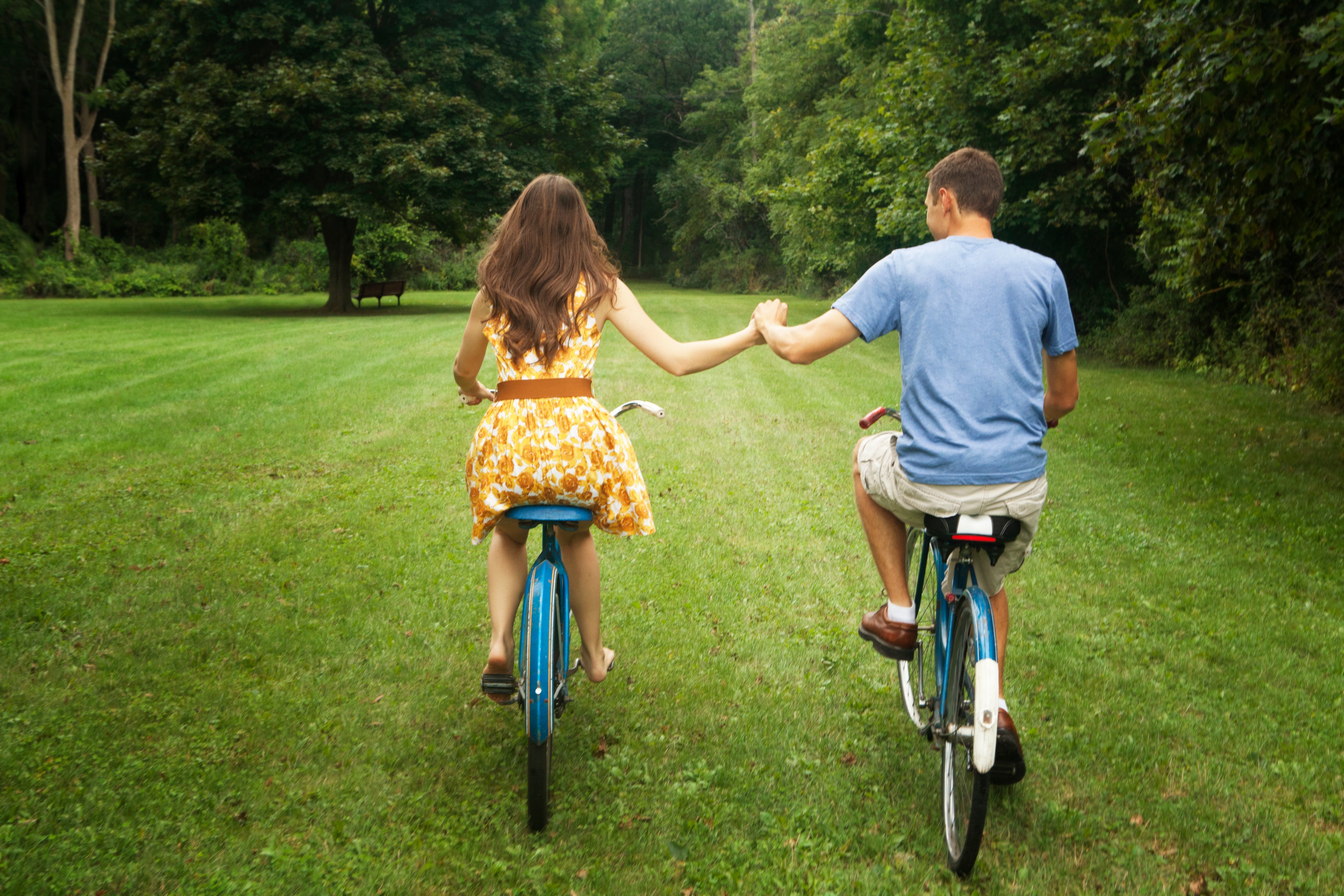 Couple holding hands while riding bicycles
