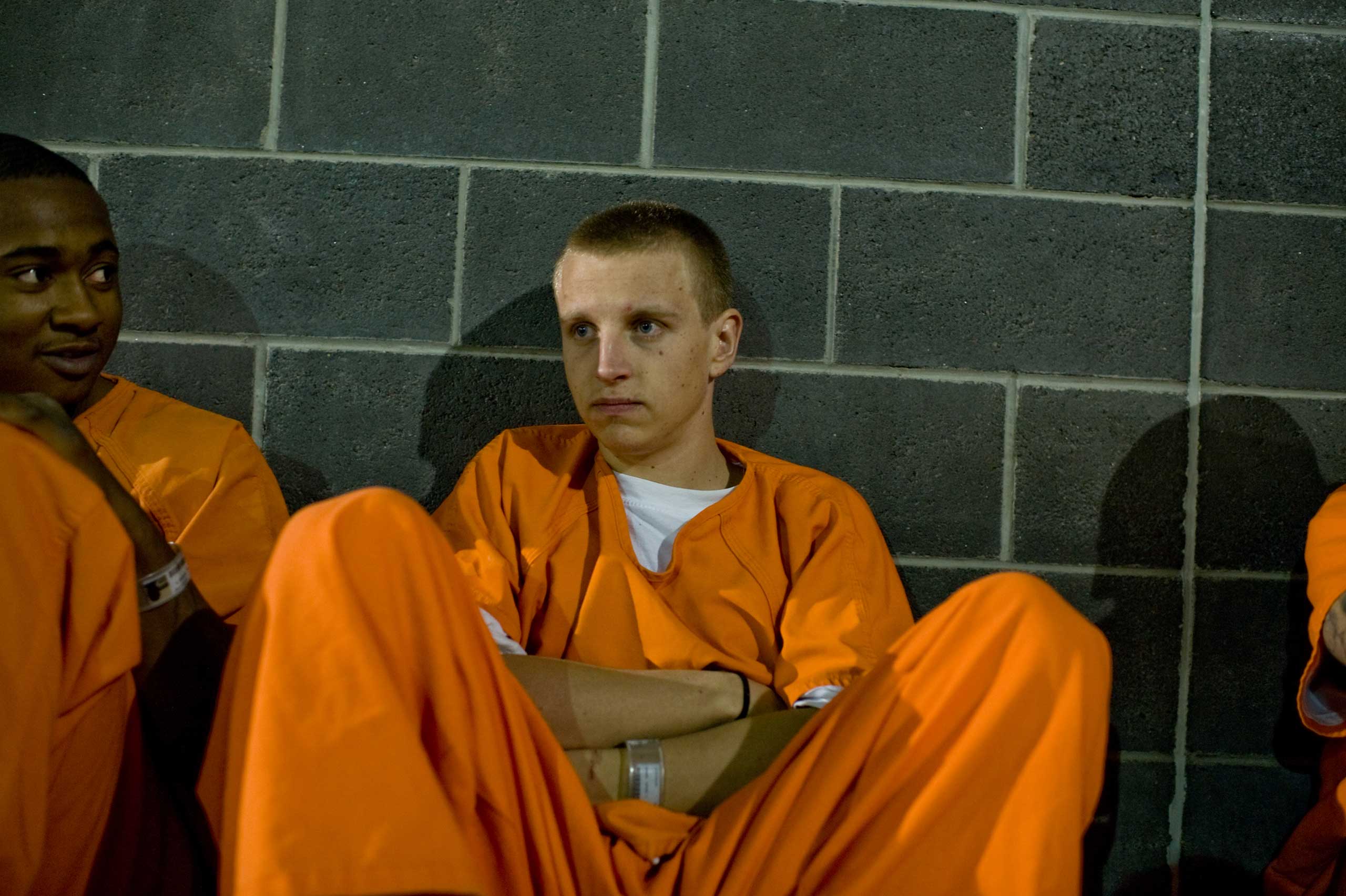 David, 19, sits in the recreation yard of the jail at night.