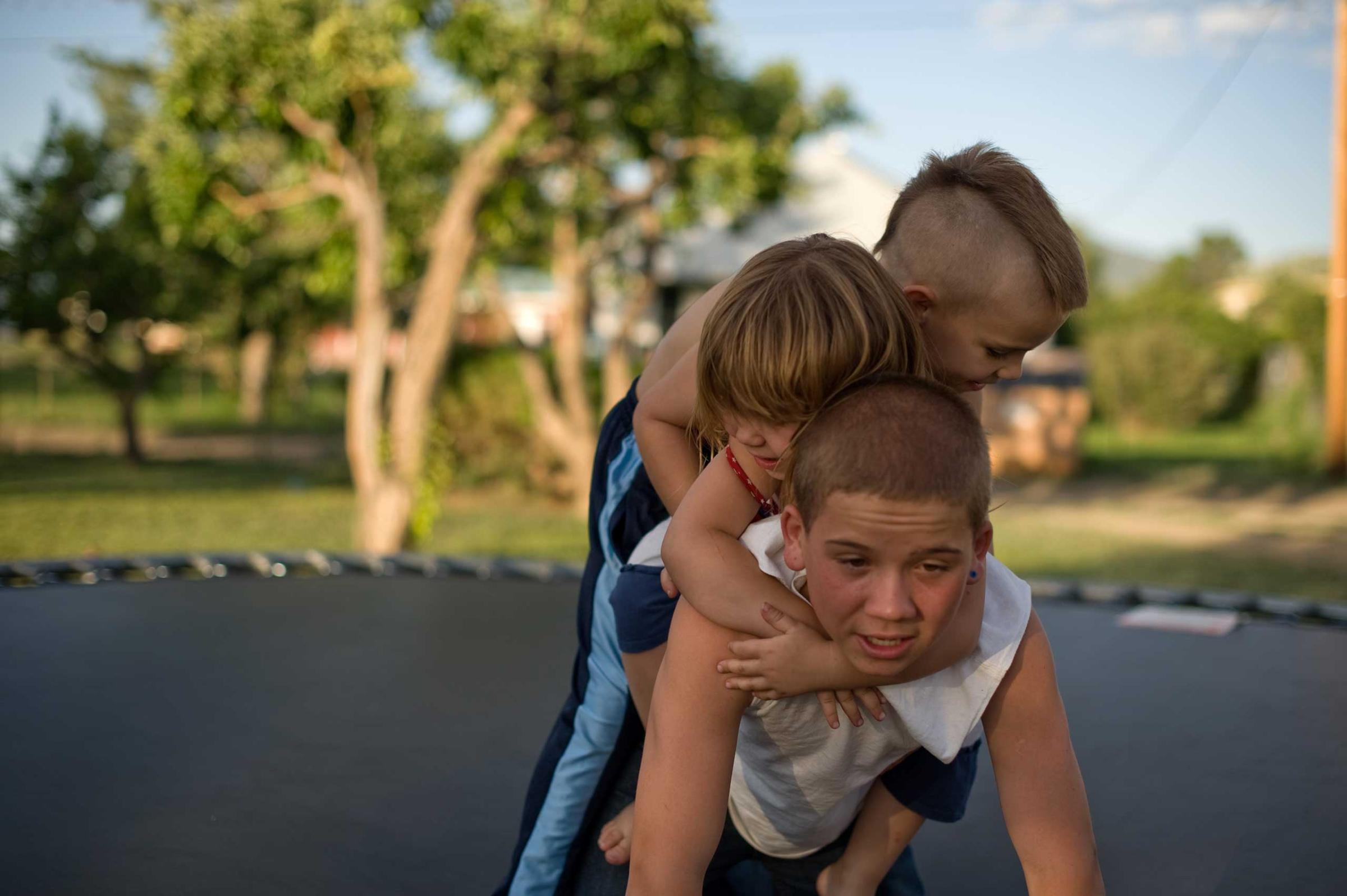 Vinny, Michael and Elycia play together on a trampoline. This is Vinny's first visit with his siblings since beginning his new life with his aunt.