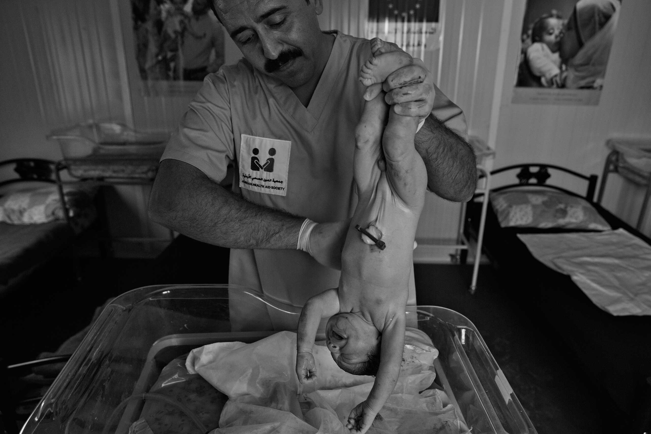 December 2013. Za'atari refugee camp, Jordan. This newborn baby boy was delivered by an NGO doctor assisted by a nurse and later by a member of the baby's family.