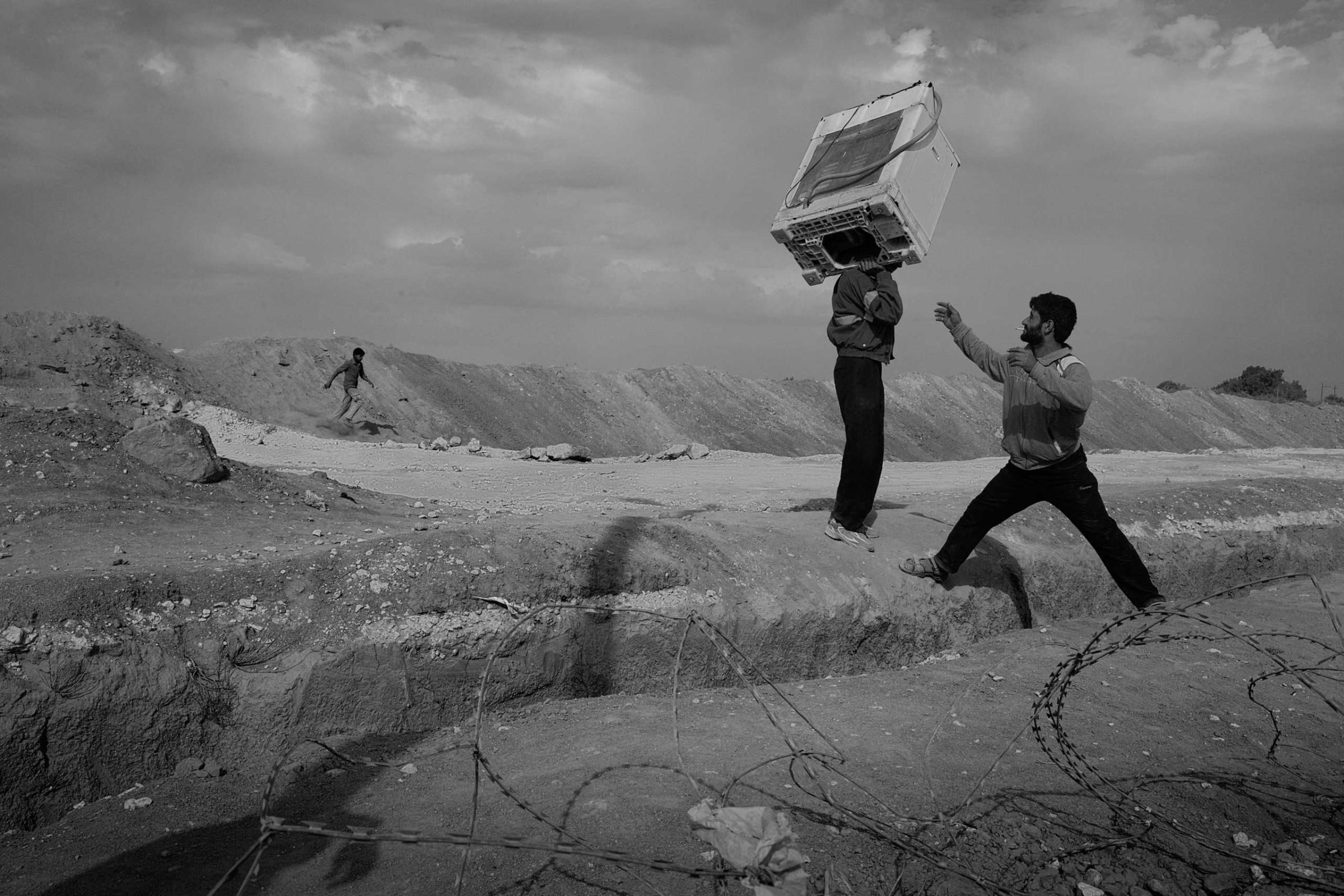 December 2013. Za'atari refugee camp, Jordan. Refugees carry an oven into the camp after bartering or selling goods for it in Jordan.
