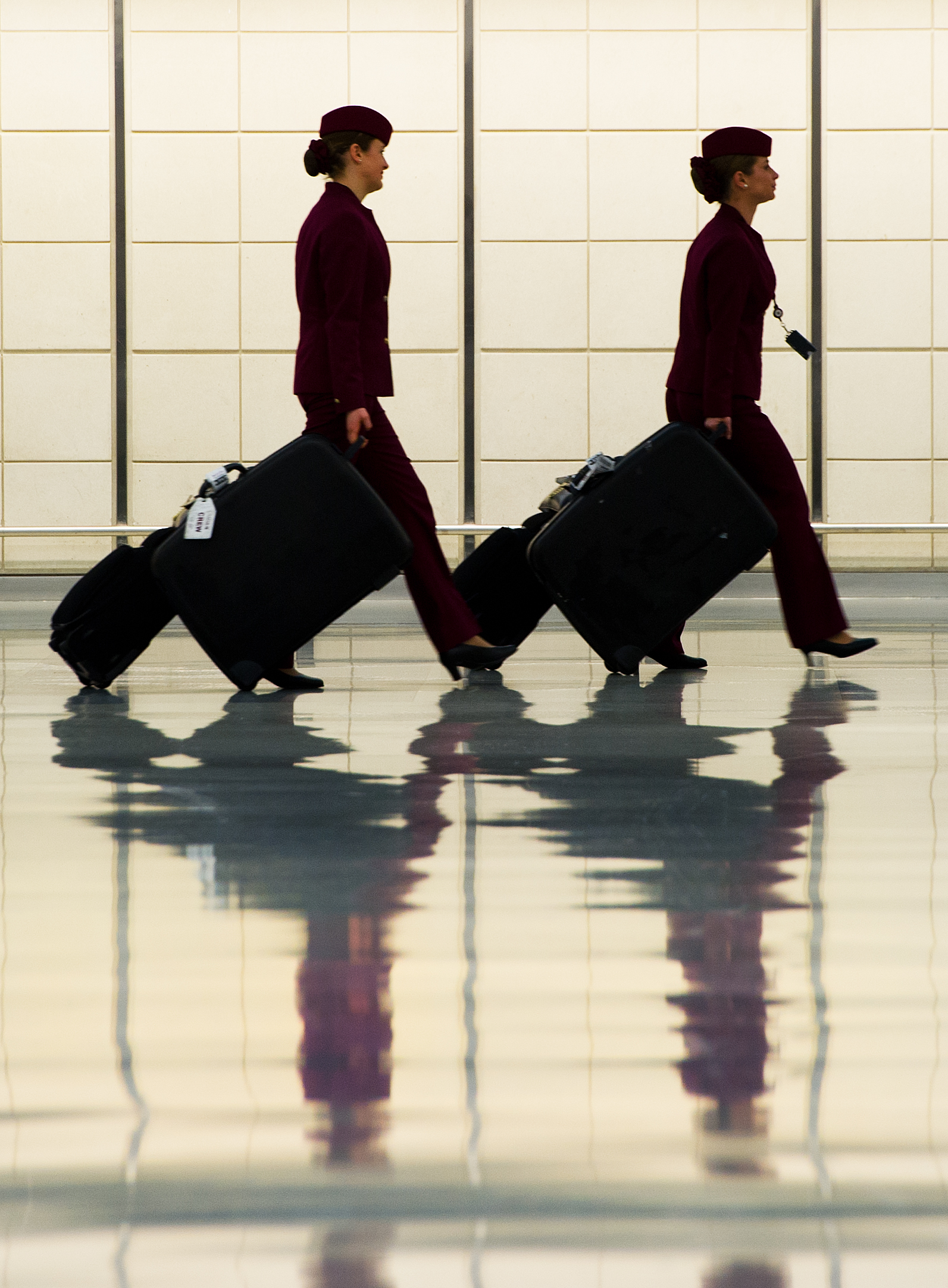 Two flight attendants walk in the luggag