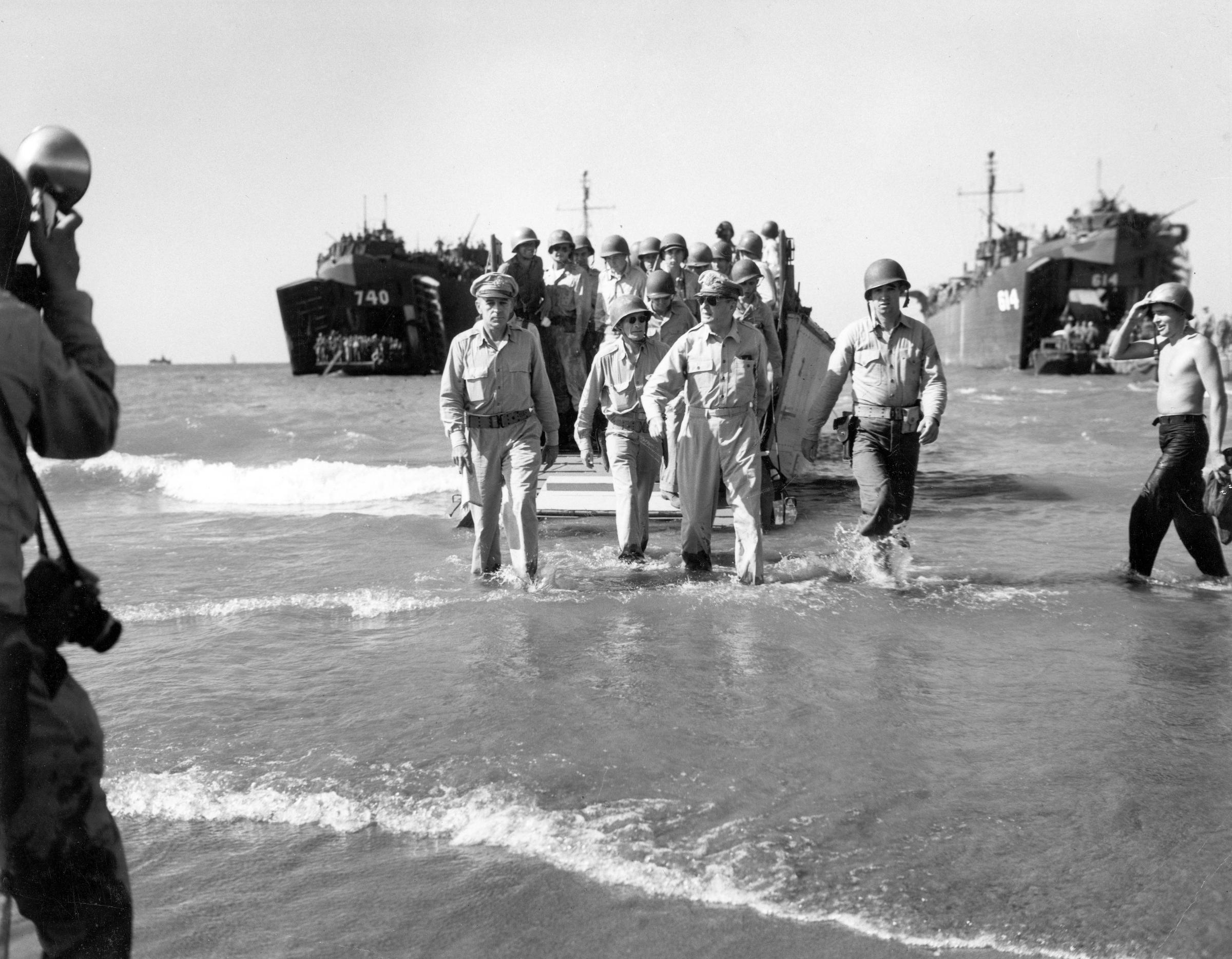 Gen. Douglas MacArthur with Gen. Richard Sutherland (left) and Col. Lloyd Lehrbas (second from left) walks through the surf to the beach at Lingayen, Luzon, the Philippines, Jan. 9, 1945.