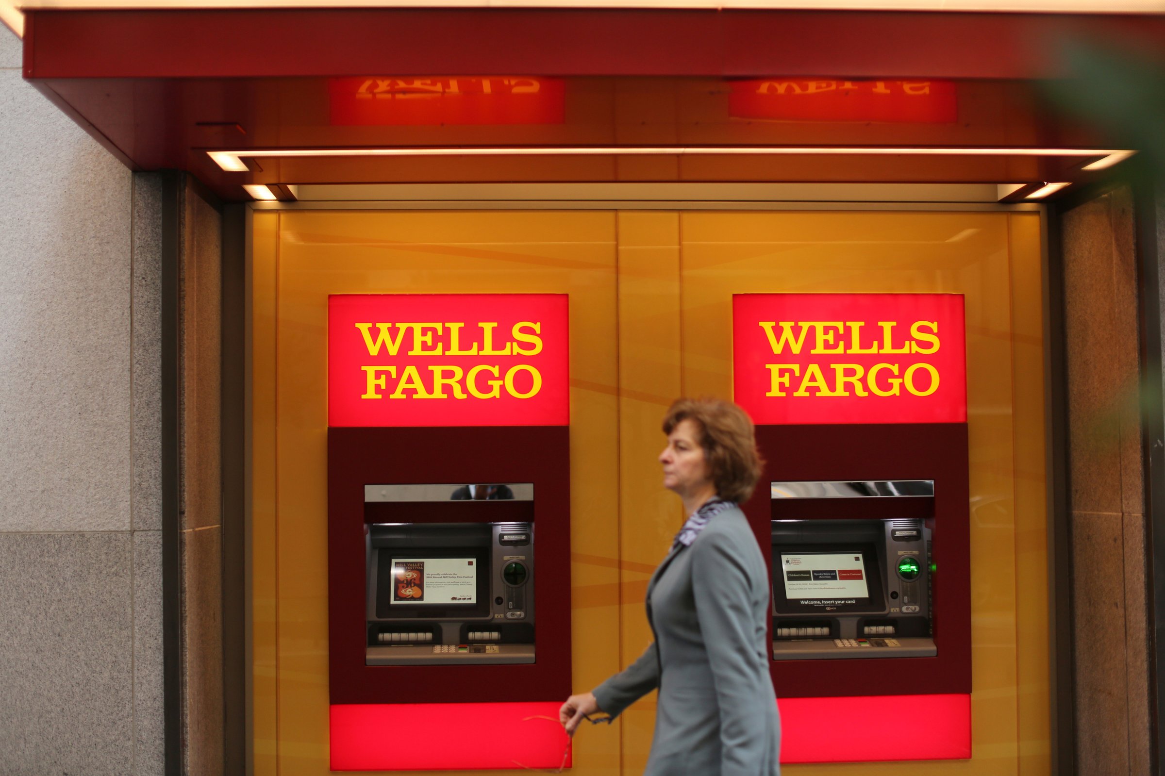 A woman walks past teller machines at a Wells Fargo bank in San Francisco, California.
