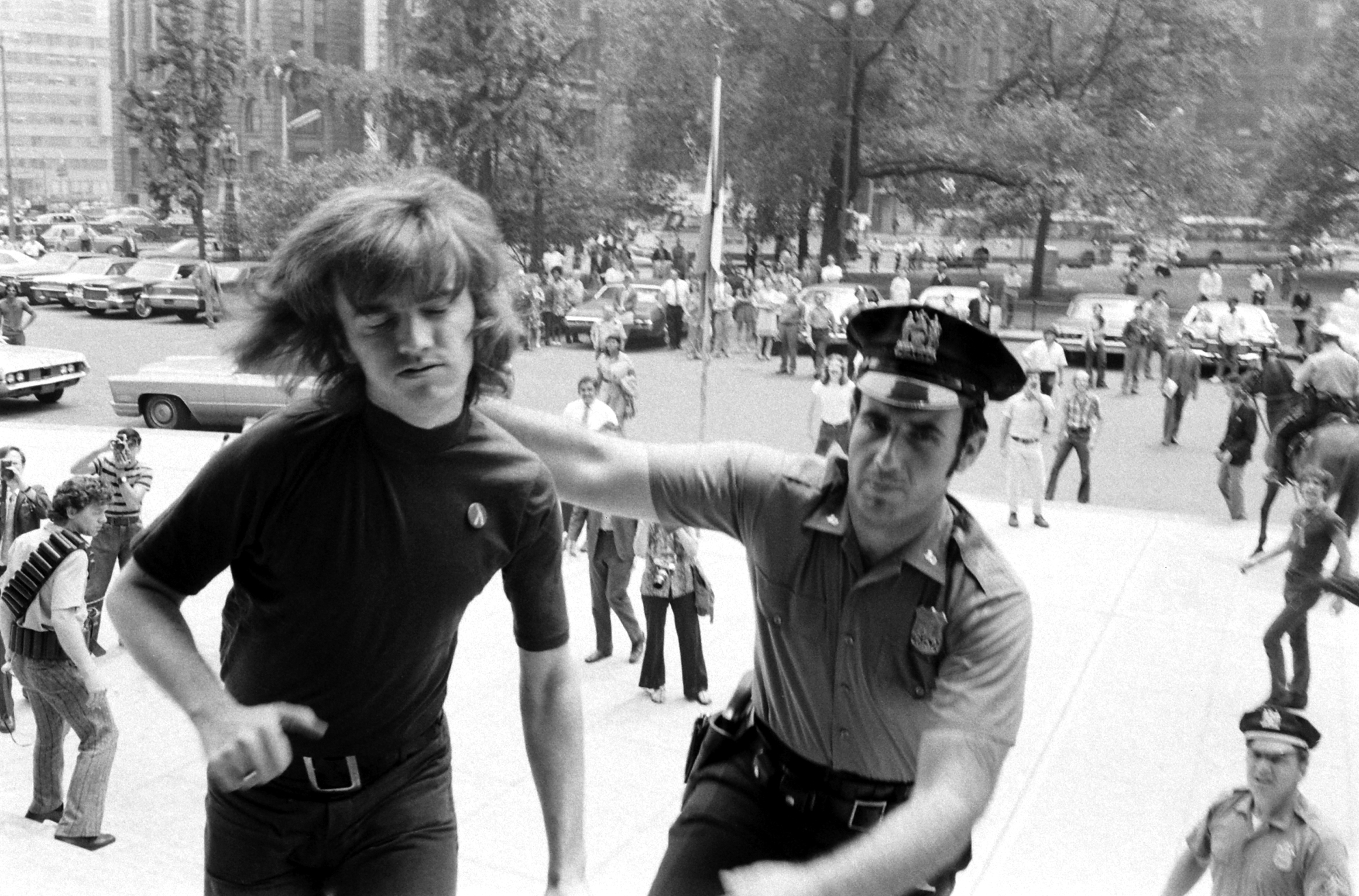 Collared by a patrolman after he deliberately crossed police barricades at New York's City Hall, Gay Activists Alliance President Jim Owles submits to arrest. Members of his organization were protesting City Council reluctance to debate a fair employment bill for homosexuals.