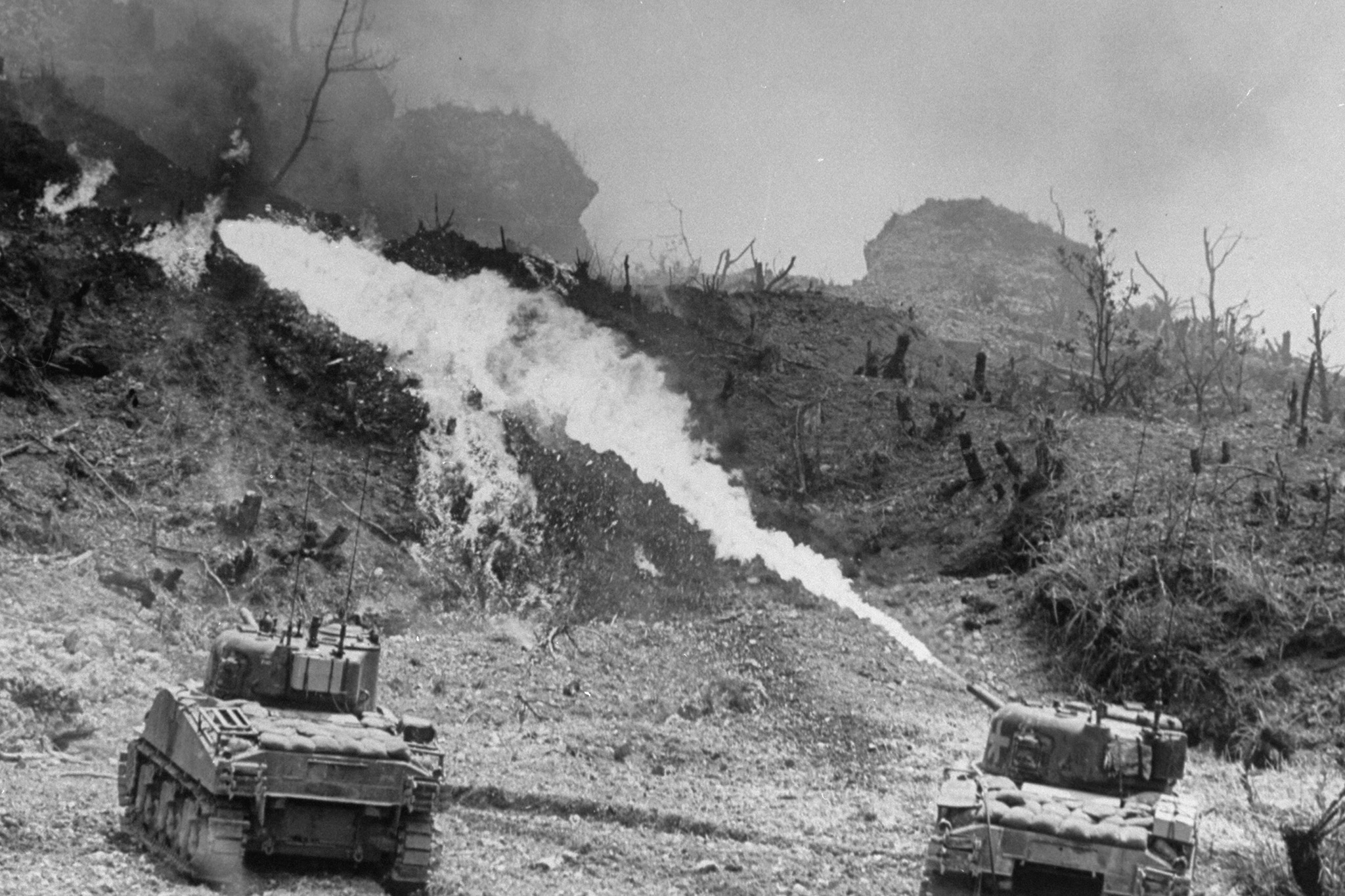 American tanks of the Army 7th Division using specially equipped flame throwers to burn Japanese defenders out of their caves and pillboxes, Okinawa, 1945.