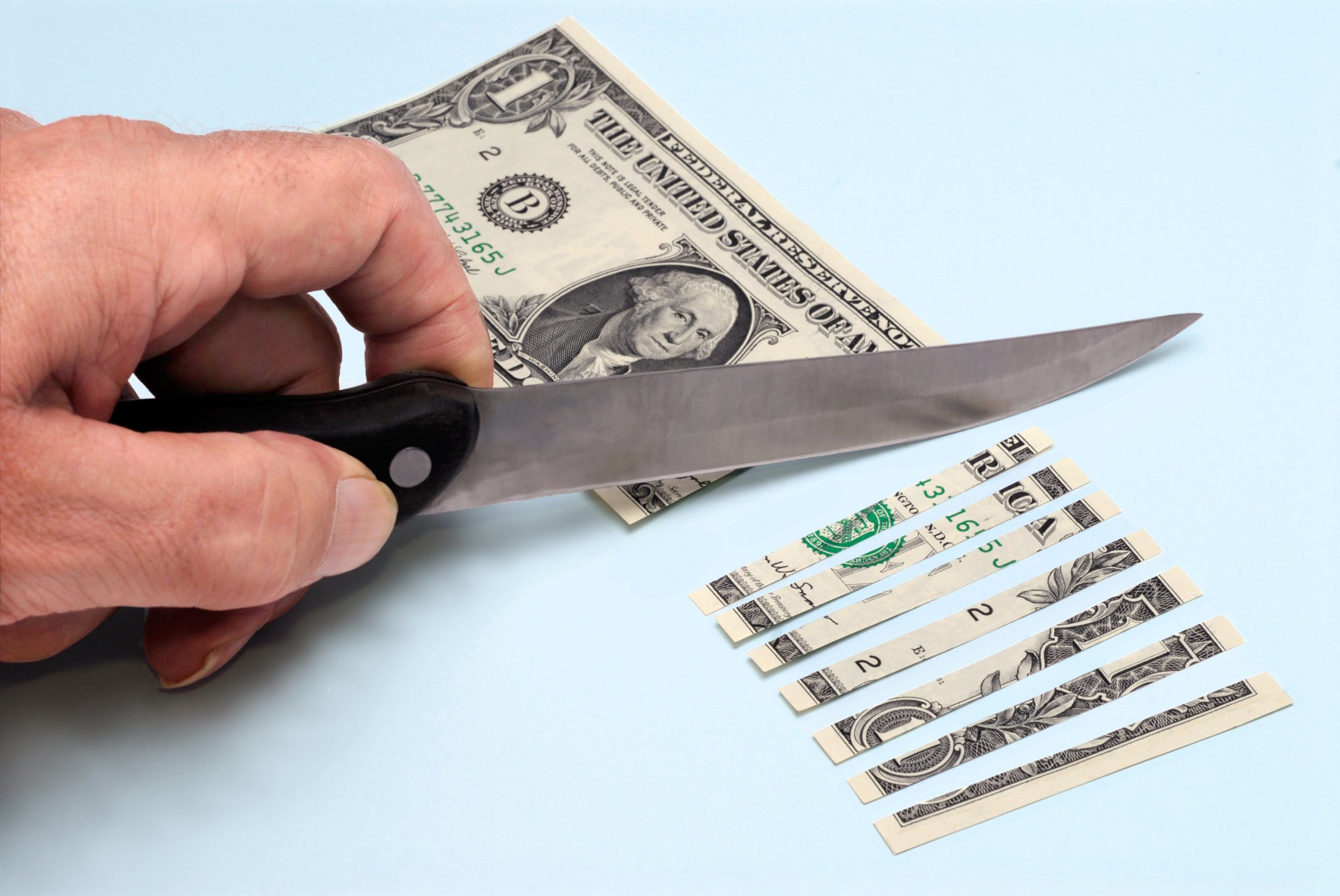 knife cutting dollar bill