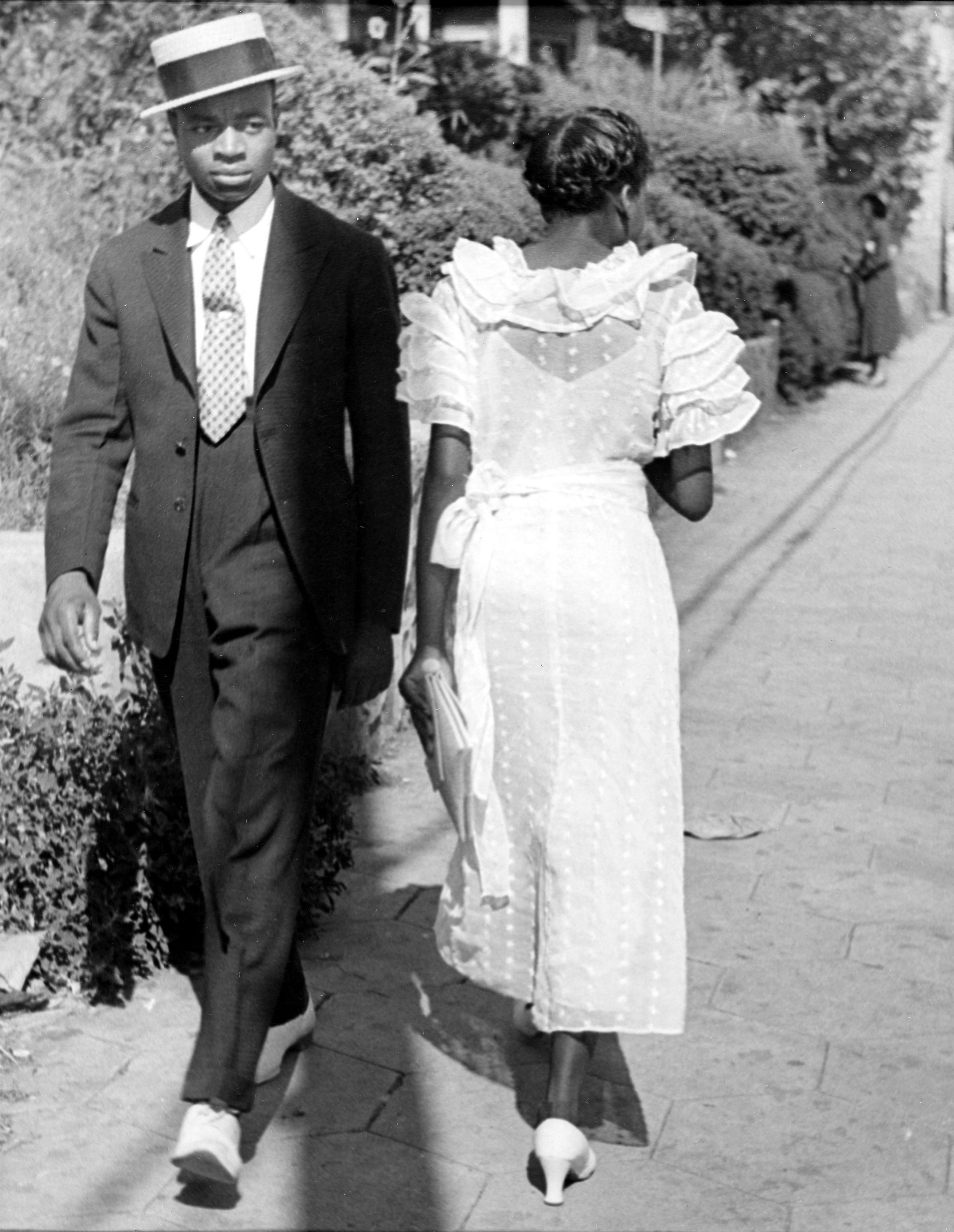 A young man and woman in Sunday finery pass on the street, Mississippi, 1936.