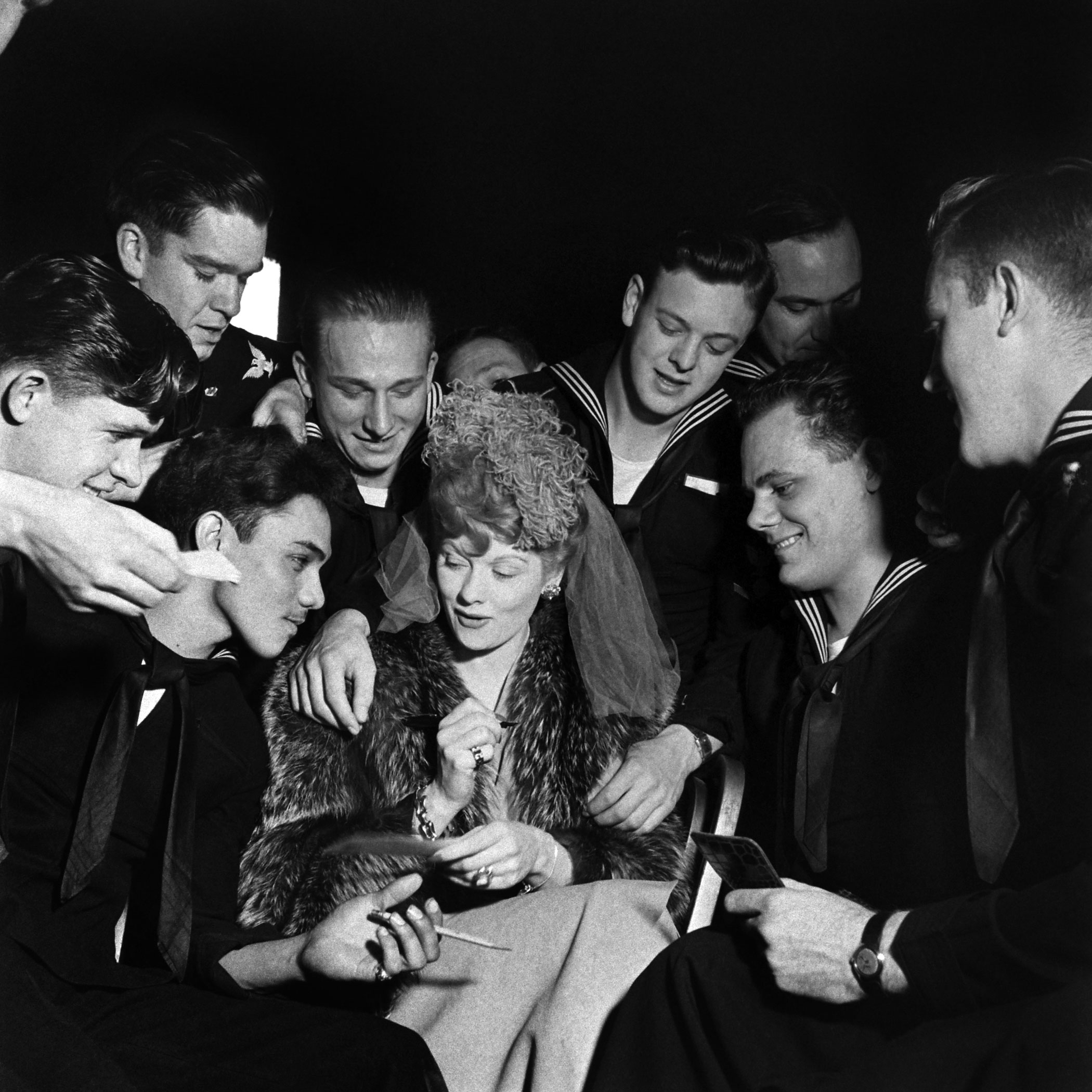 Lucille Ball signs autographs for admiring seamen at one of the January 1944 galas celebrating President Franklin D. Roosevelt's 62nd birthday.