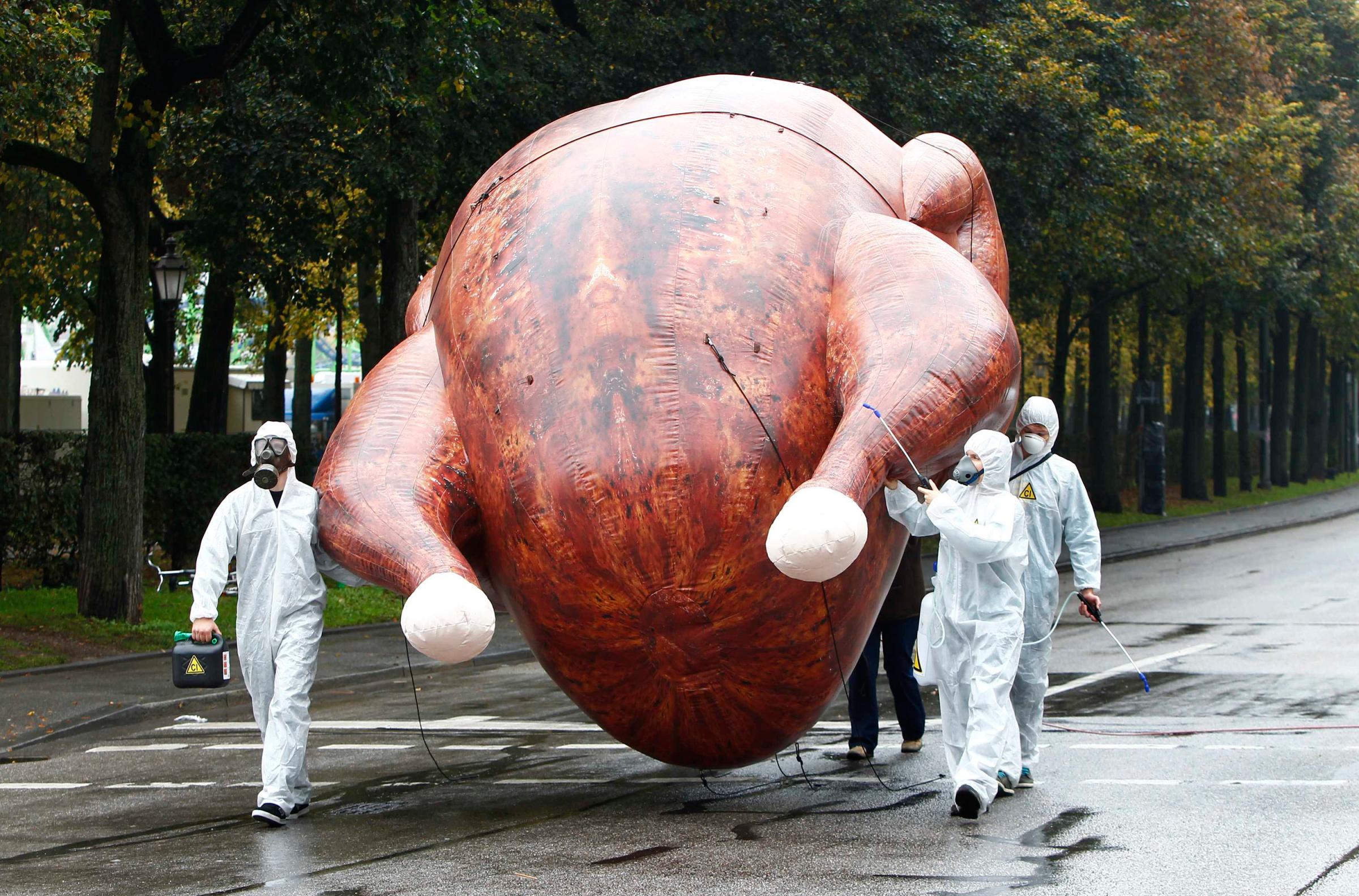 Environmental activists carry a giant inflatable chicken near Oktoberfest grounds in Munich