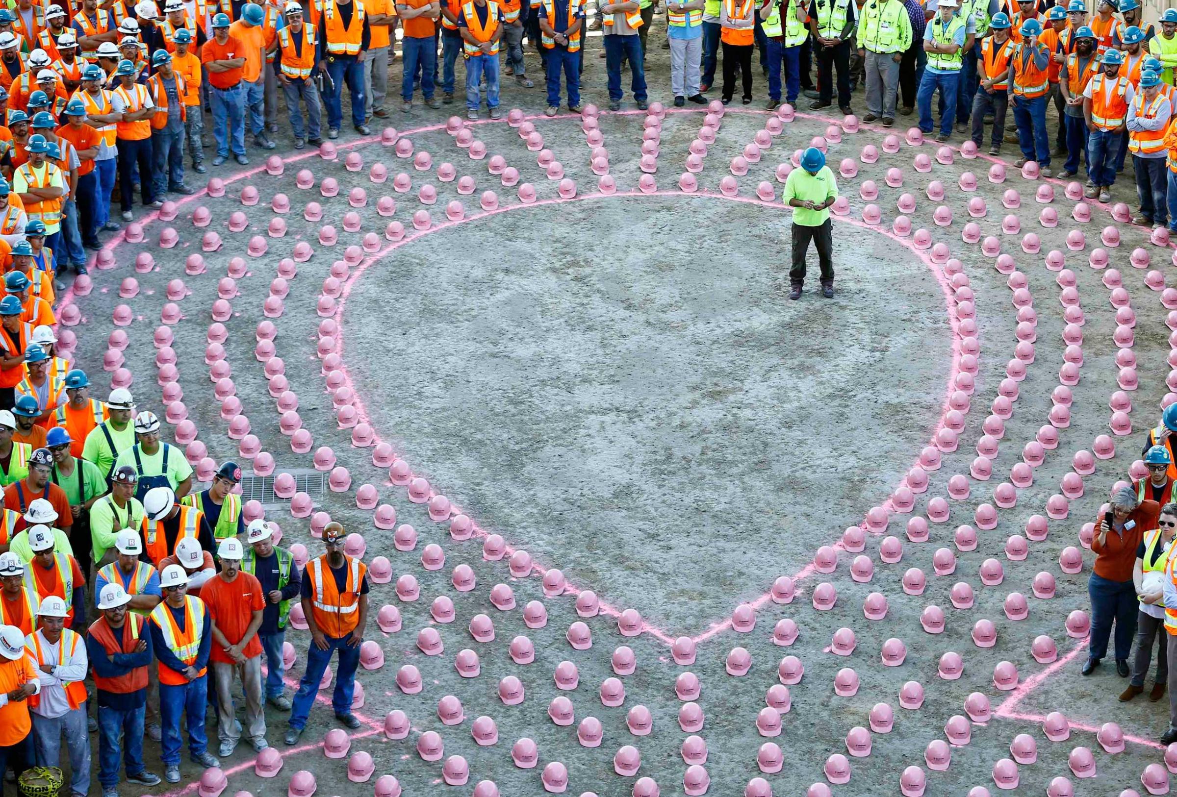 Construction workers wait to put on pink hard hats to promote the start of  Breast Cancer Awareness Month, at the UC San Diego Jacobs Medical Center construction site in  La Jolla