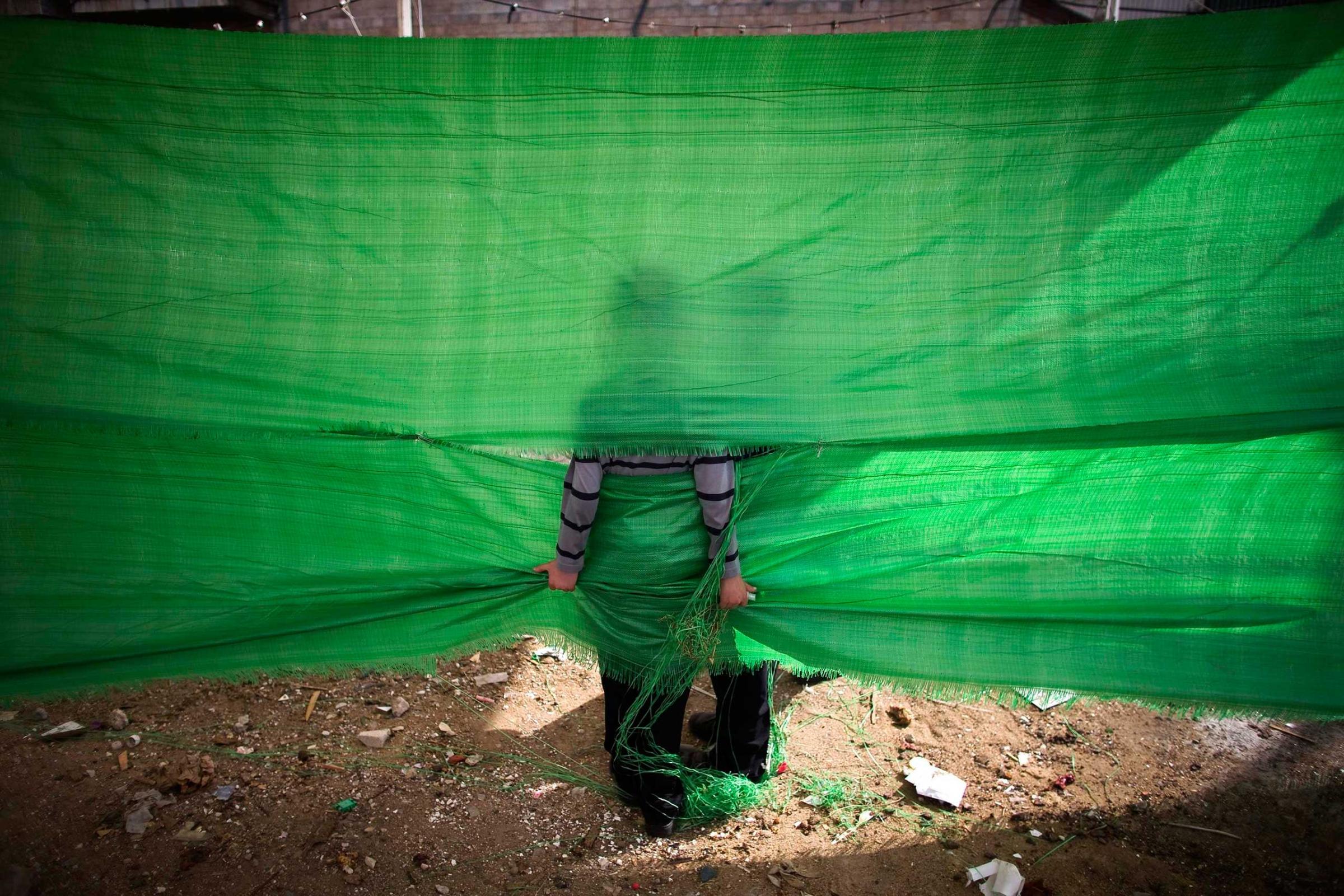 An ultra-Orthodox Jewish boy holds on to a tarp in Jerusalem