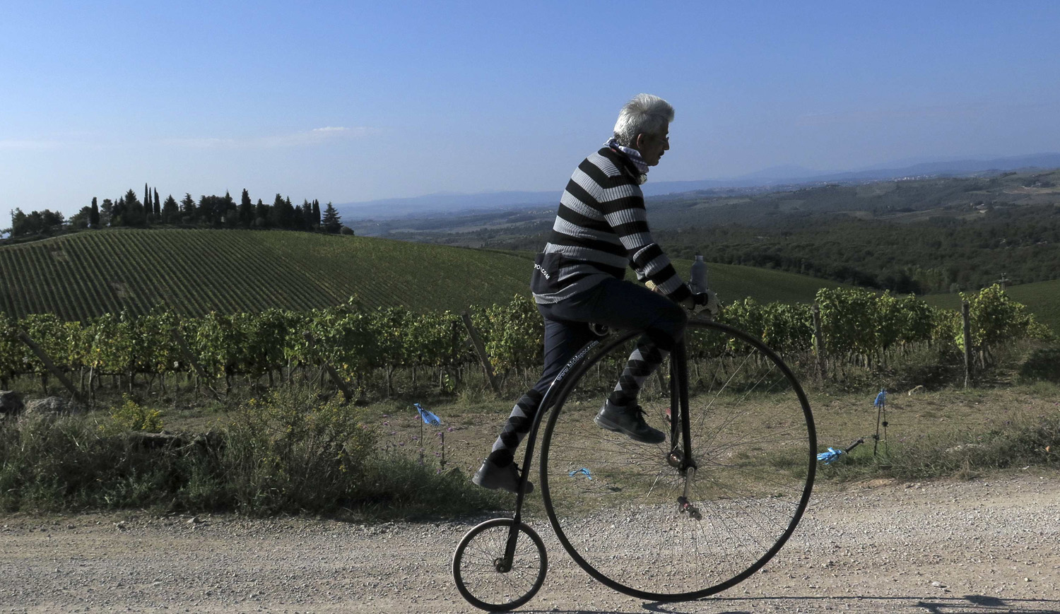 Cyclist rides on a high wheel bicycle to practices a day before the " Eroica" cycling race for old bikes in Tuscany
