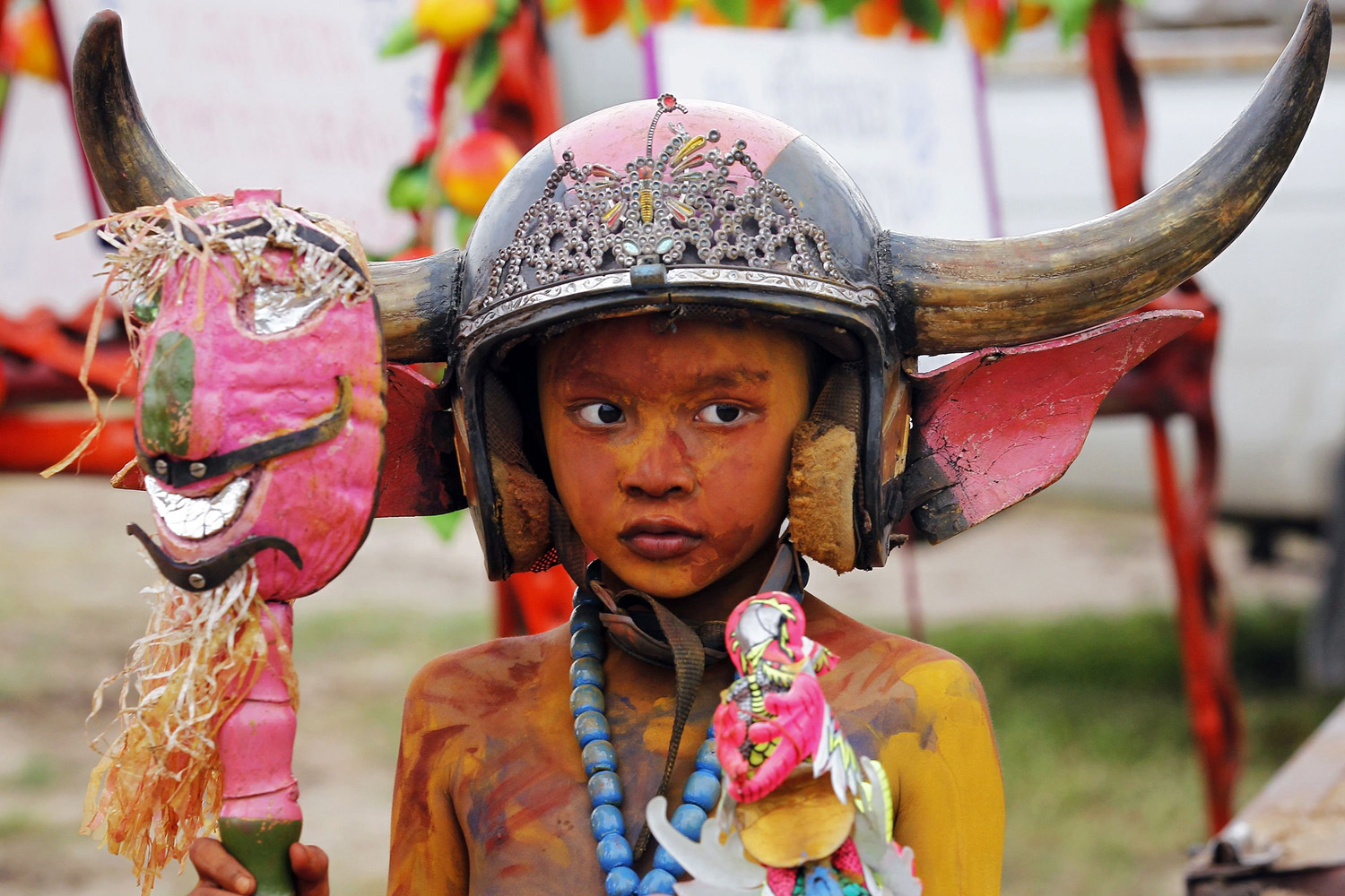 Boy wearing a horned helmet and body paint arrives for Chonburi's annual buffalo race festival