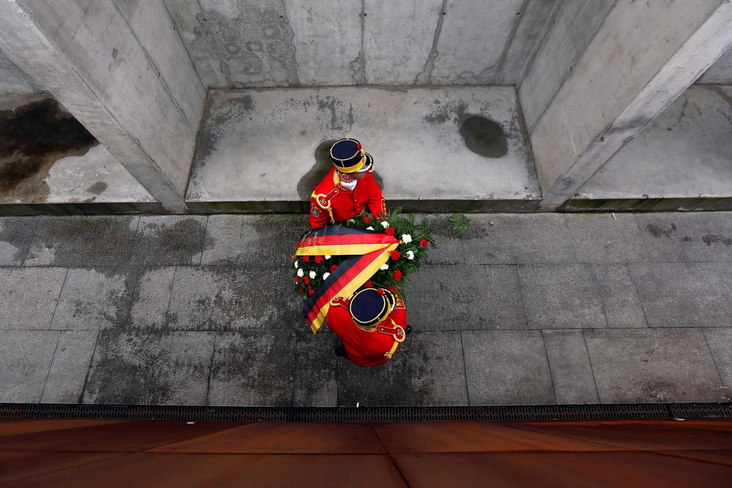 Romanian soldiers carry a wreath during ceremonies at Holocaust memorial in Bucharest