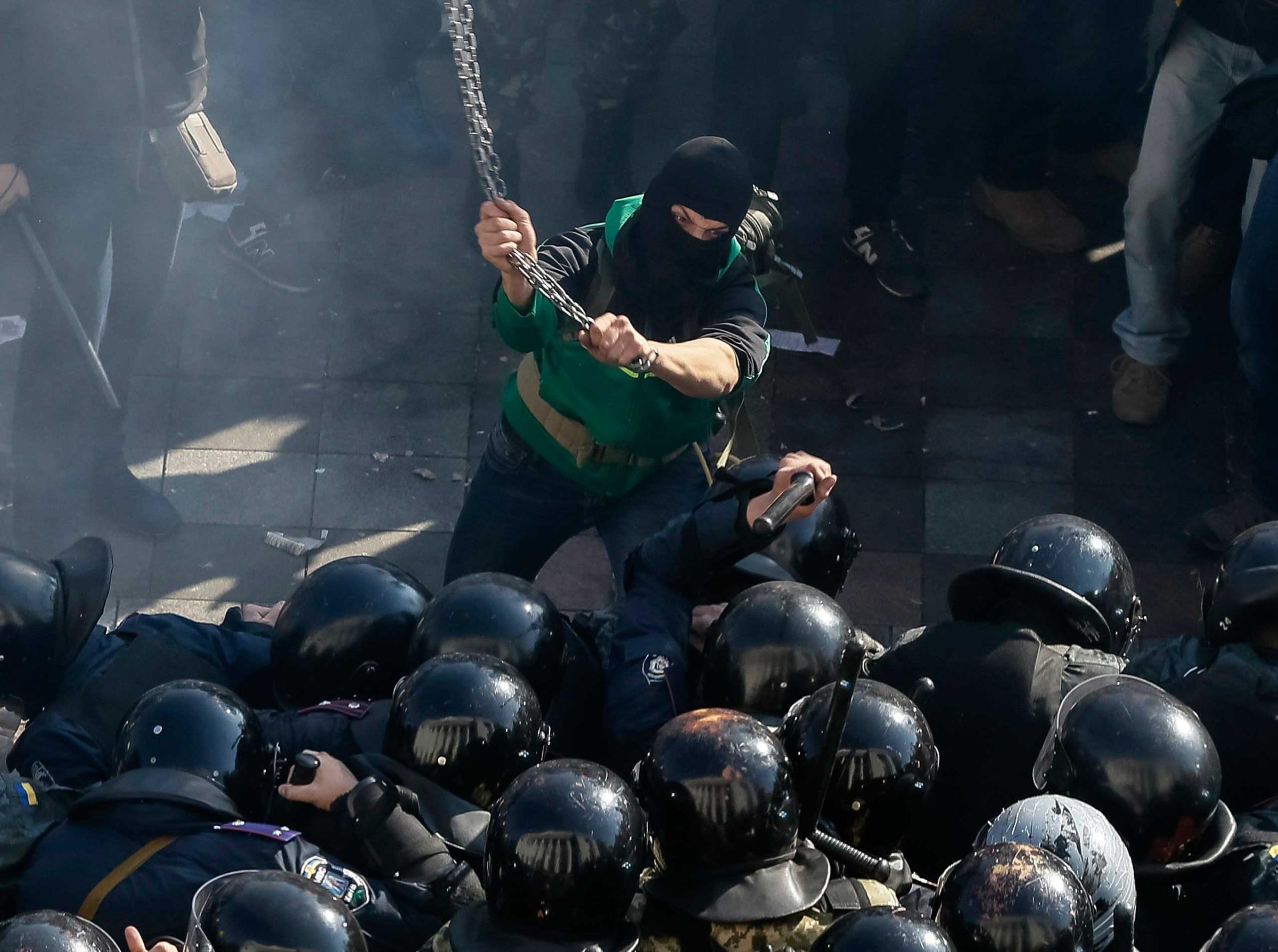 A radical protester clashes with law enforcement members on the Day of Ukrainian Cossacks during a rally near the parliament building in Kiev